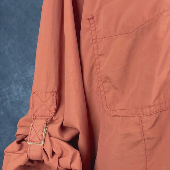 Chemisier orange brulé léger en nylon style sport, parfait pour voyager, Tilley, taille estimée à xl. Vue de la vidéo qui présente tous les détails du chemisier.