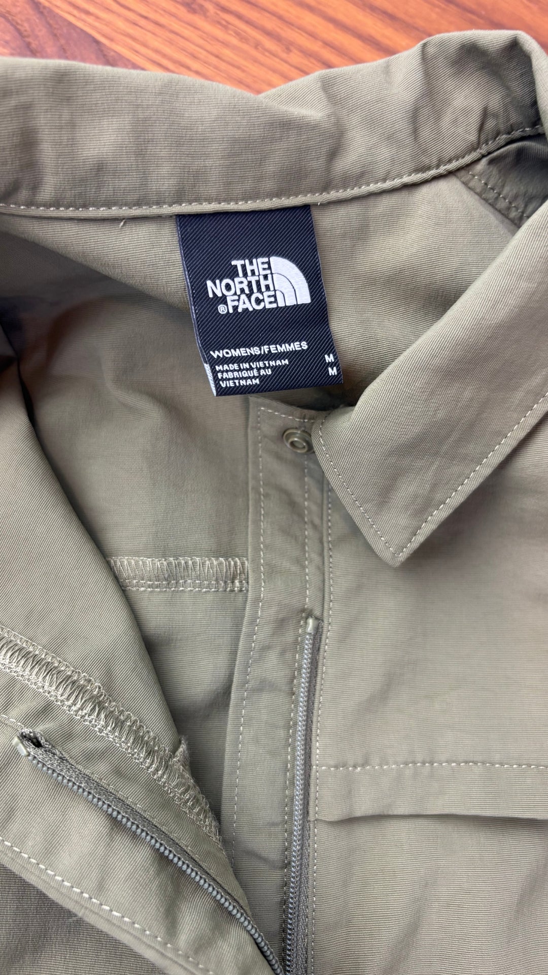 Robe chemisier vert olive avec fermeture à glissière, parfaite pour voyager The North Face, taille medium. Vue de l'étiquette.