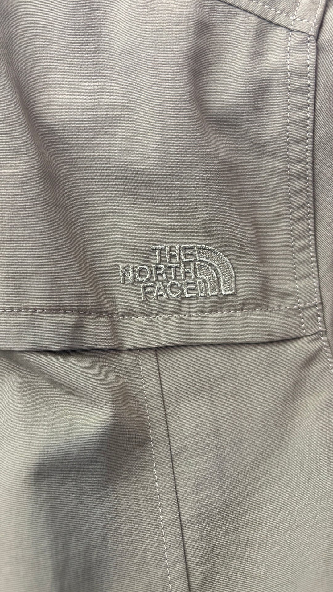 Robe chemisier vert olive avec fermeture à glissière, parfaite pour voyager The North Face, taille medium. Vue du logo brodé ton sur ton sur l'épaule droite.
