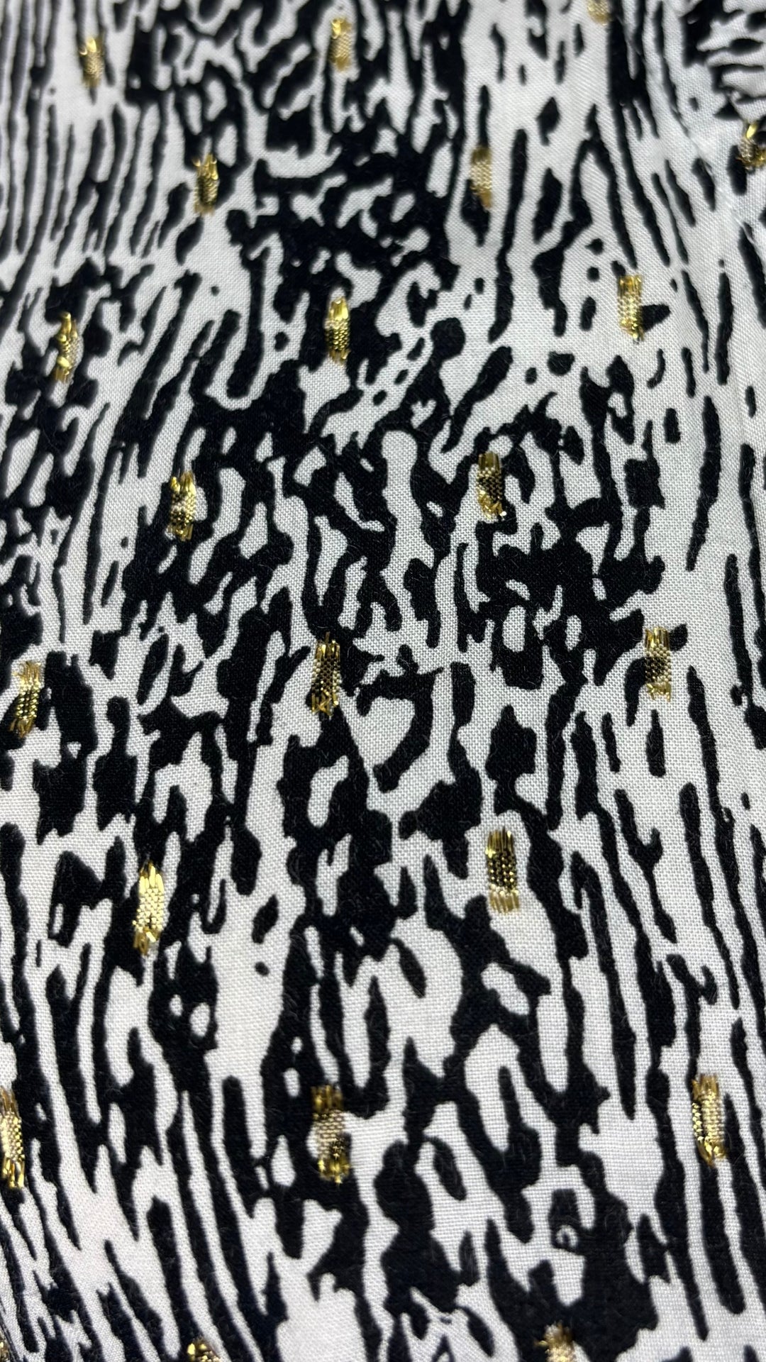 Robe légère et festive à motif noir et doré Suncoo, taille 1 (small). Vue de près du tissu.