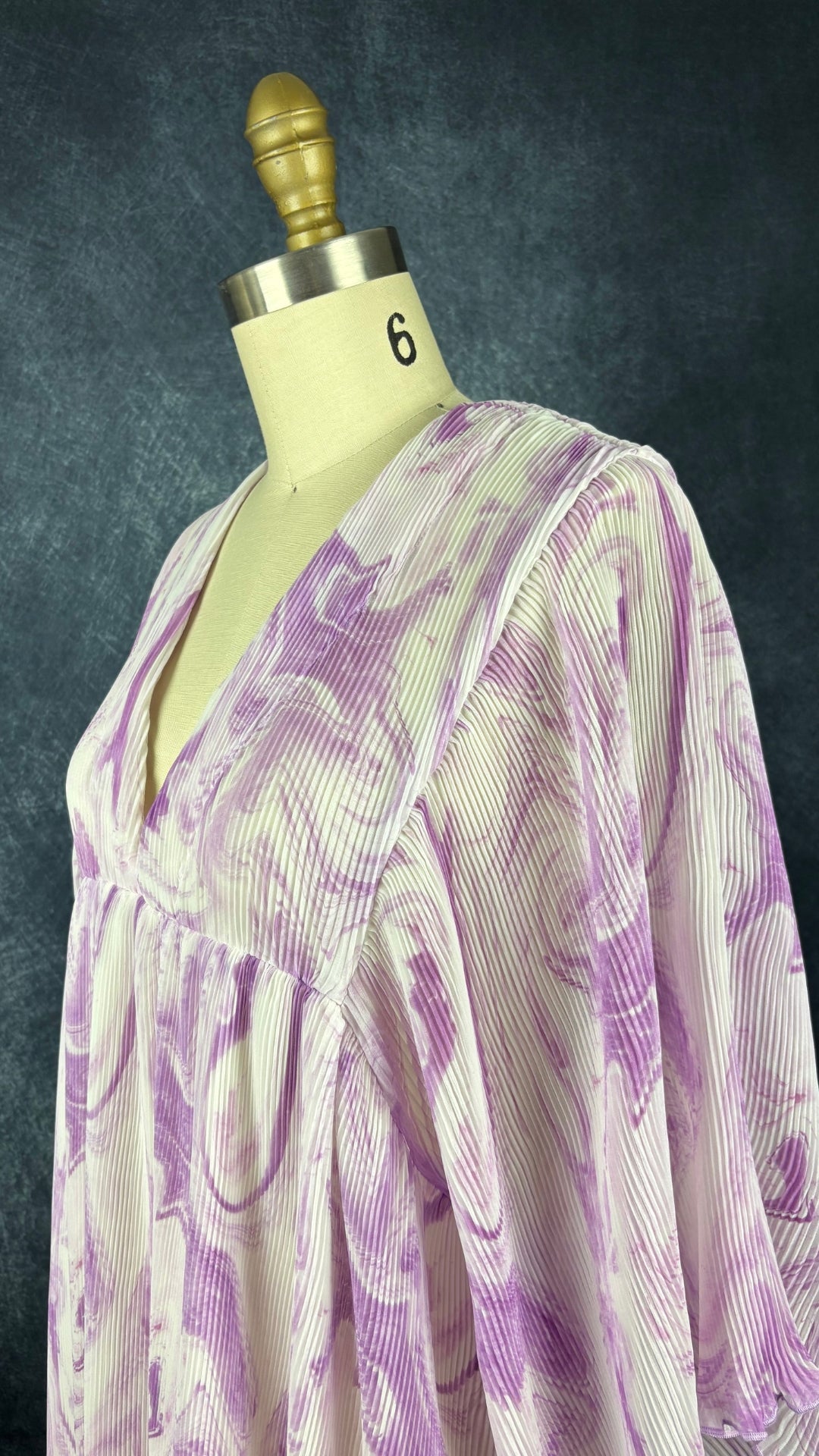 Robe à motifs de tourbillons lilas et mauve, finement plissée Ganni, taille s/m. Vue de l'encolure.