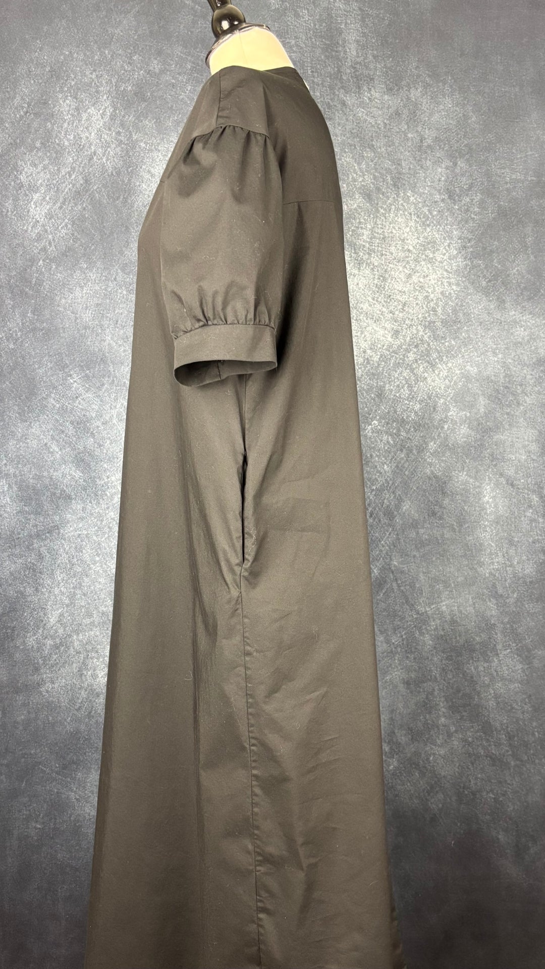 Robe noire longue à petite manche bouffante Humility, taille estimée à large. Vue de côté.