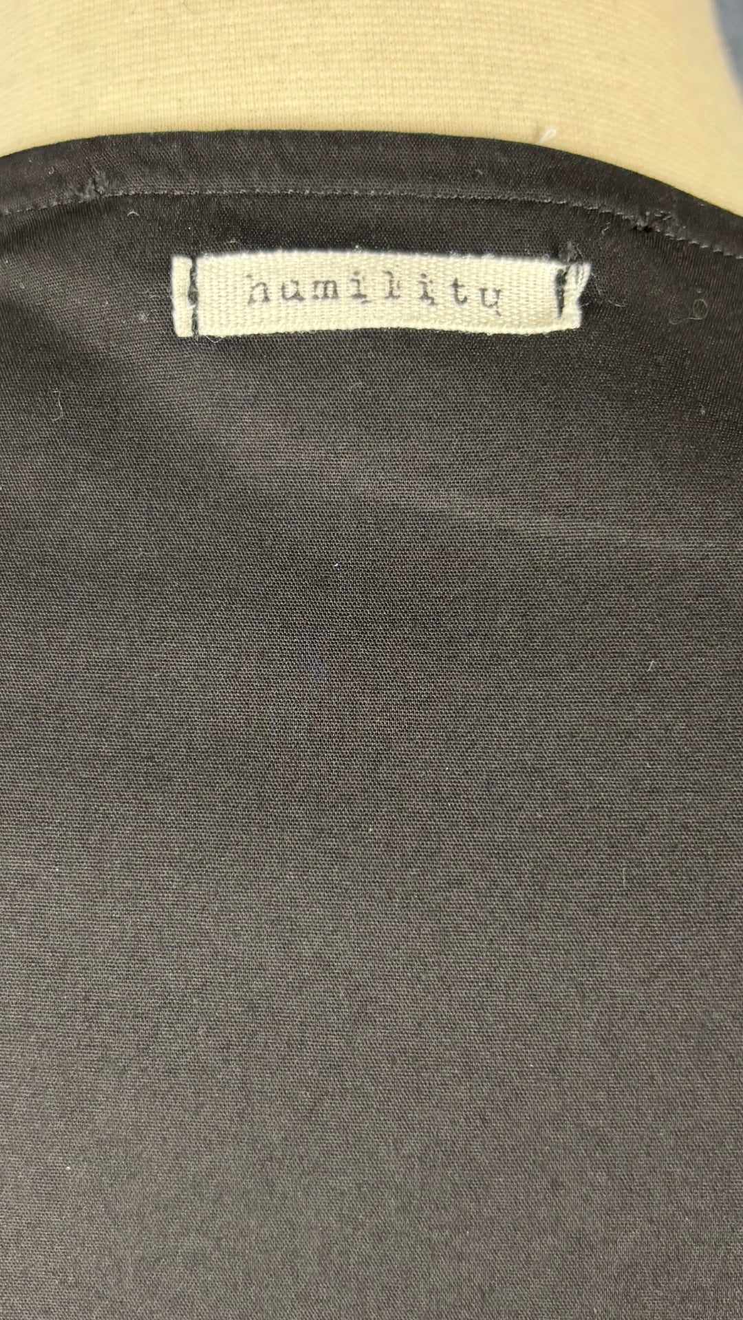 Robe noire longue à petite manche bouffante Humility, taille estimée à large. Vue de l'étiquette.