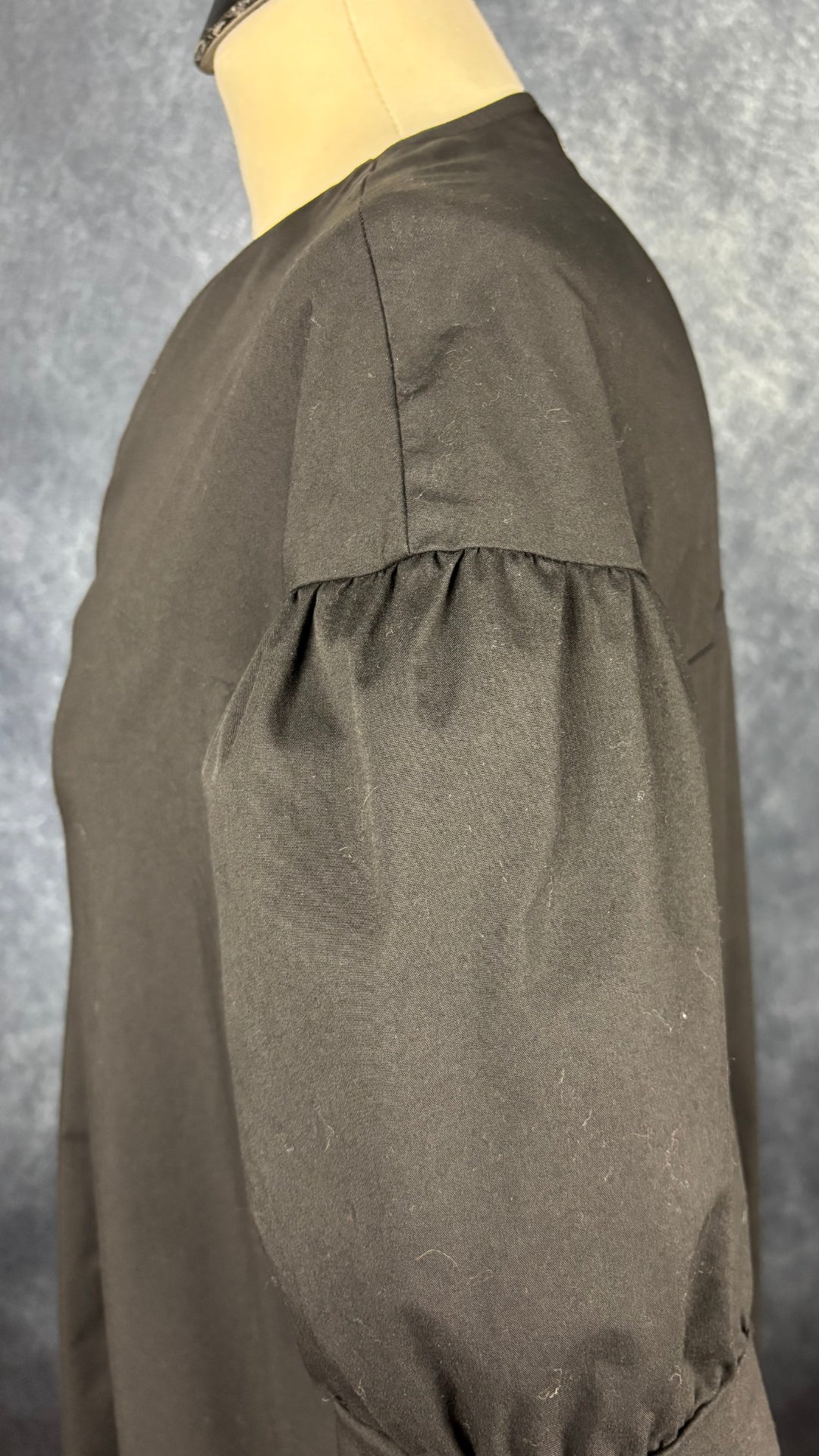 Robe noire longue à petite manche bouffante Humility, taille estimée à large. Vue de la manche.