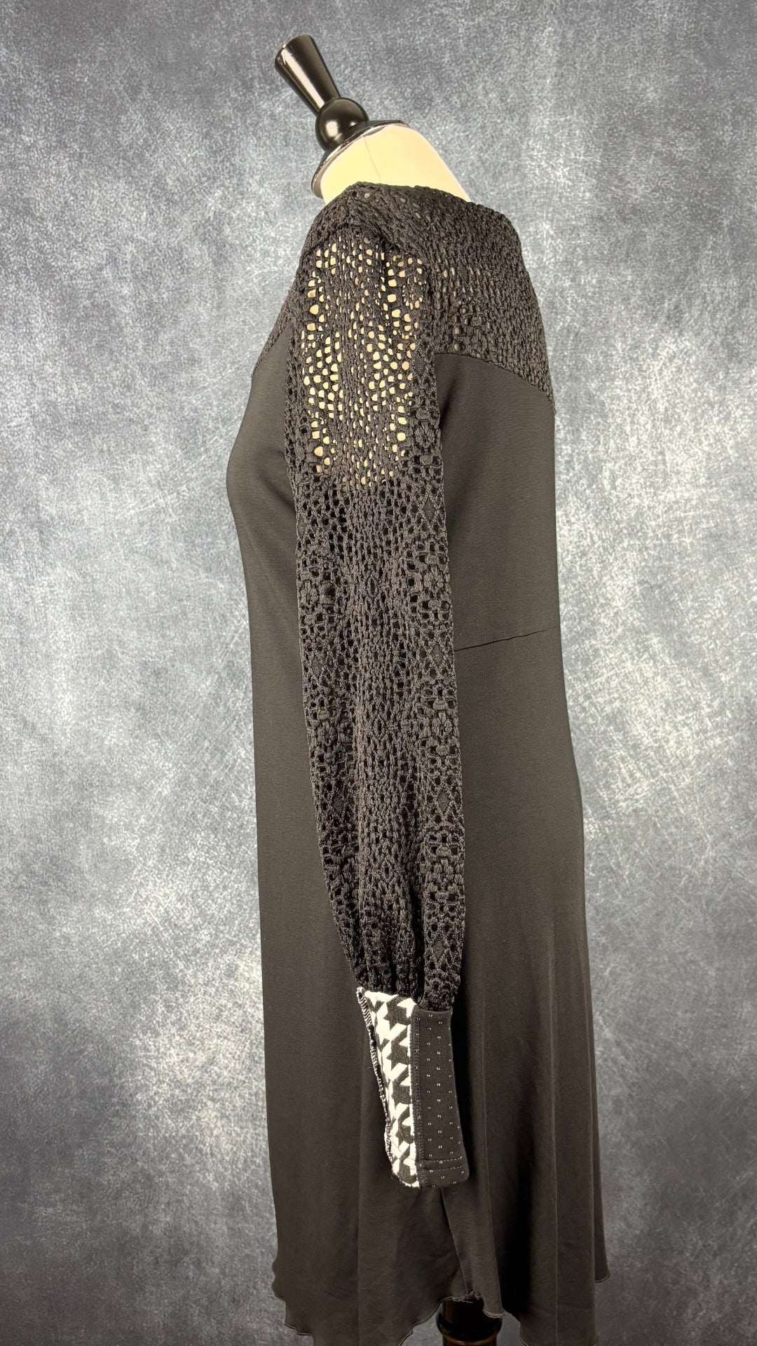 Robe noire à manches longues en dentelle Myco Anna, taille large. Vue de côté.