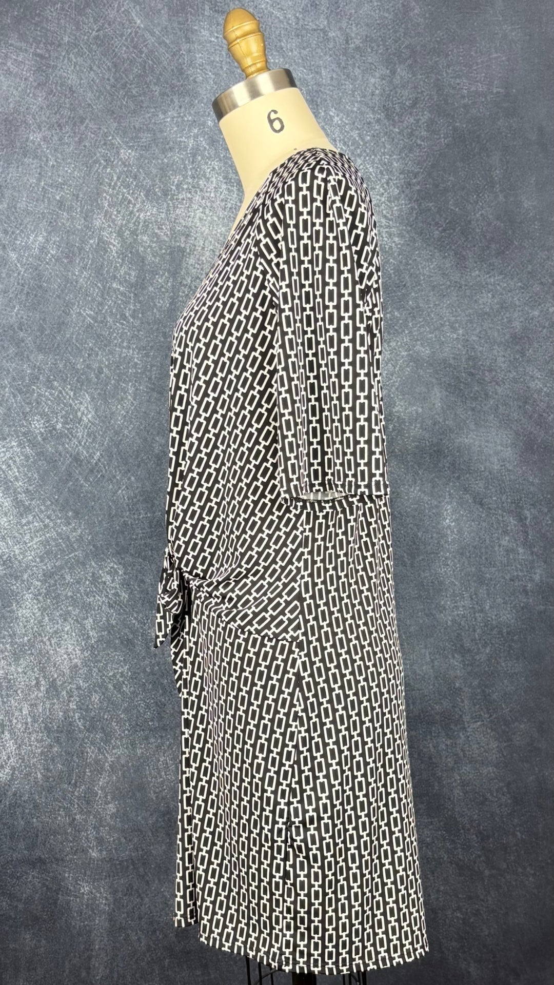Robe noire à motifs géométriques écru, nouée à l'avant, Judy Judy Design, taille estimée à small/medium. Vue de côté.