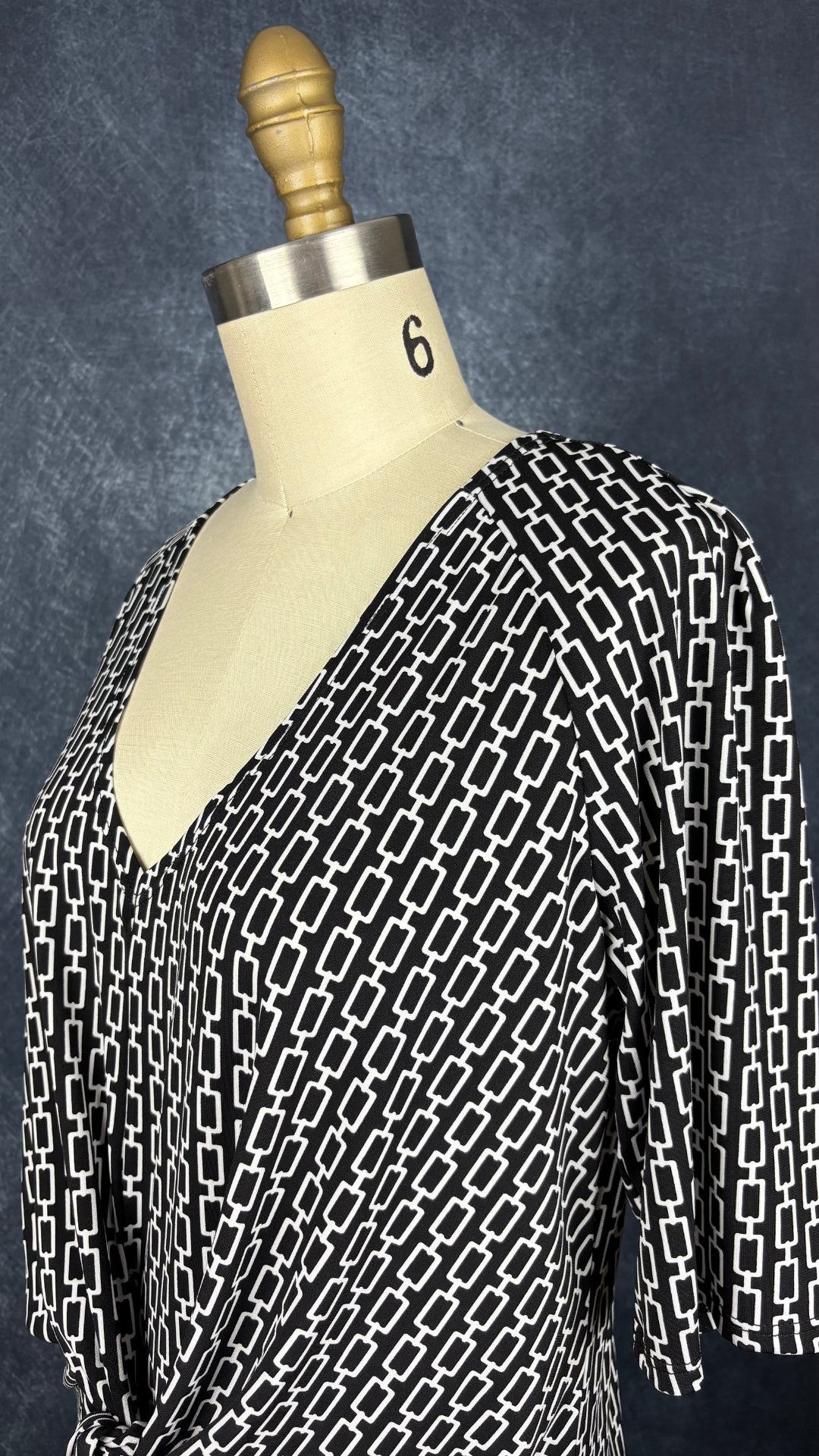 Robe noire à motifs géométriques écru, nouée à l'avant, Judy Judy Design, taille estimée à small/medium. Vue de l'encolure.