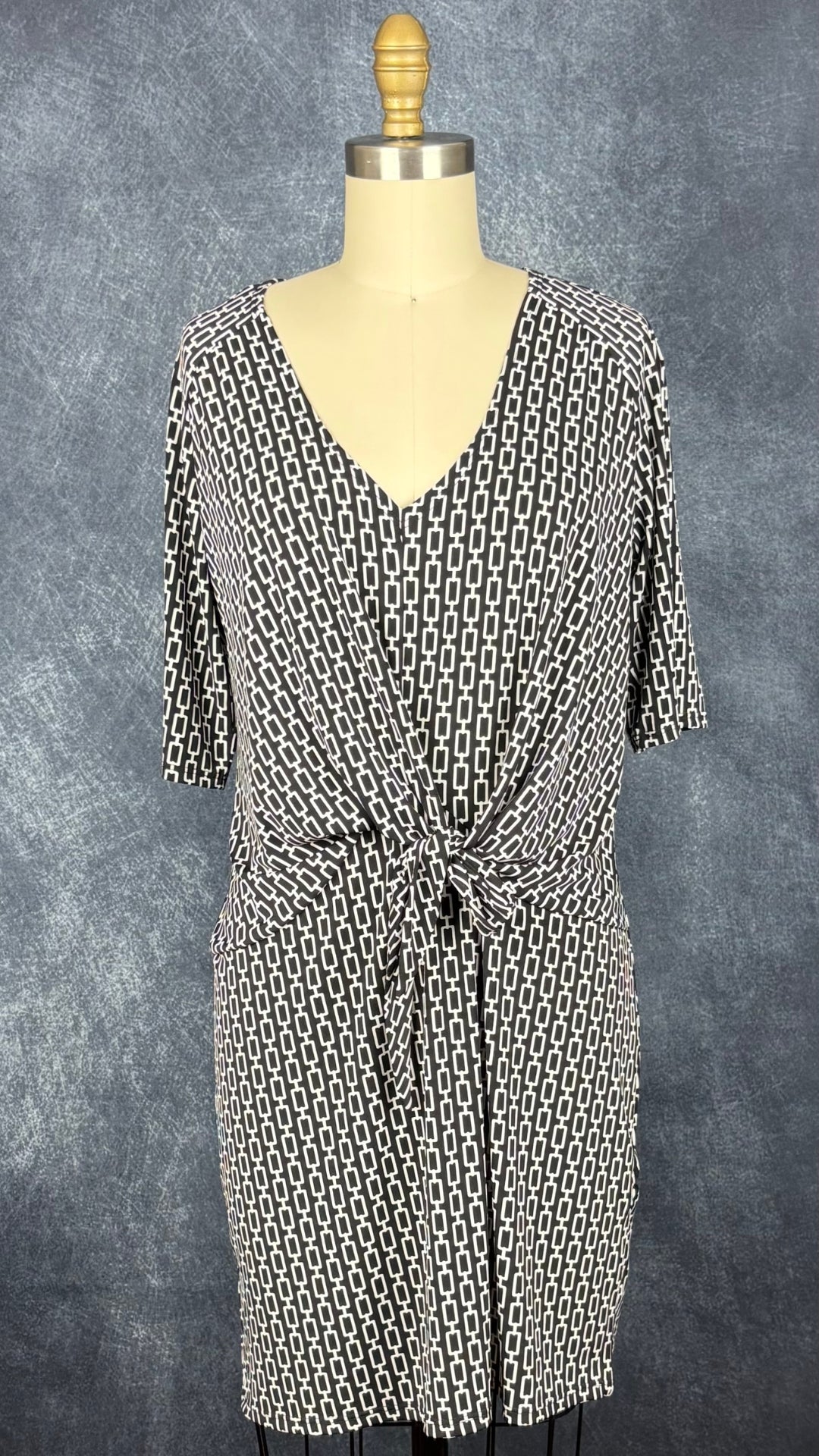 Robe noire à motifs géométriques écru, nouée à l'avant, Judy Judy Design, taille estimée à small/medium. Vue de face.