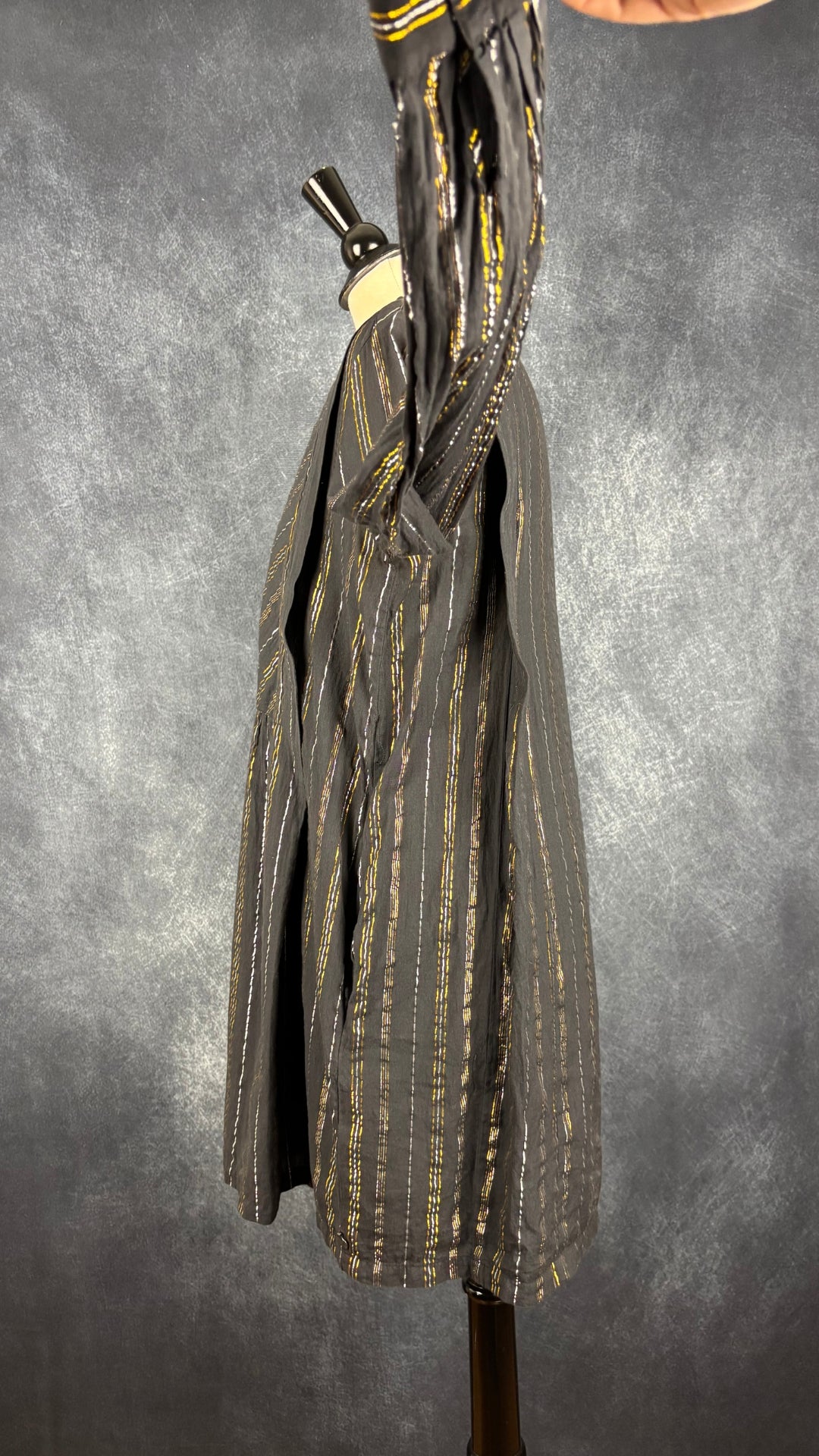 Robe noire à rayures or et argent Scotch & Soda, taille estimée à medium. Vue de côté, manche relevée.