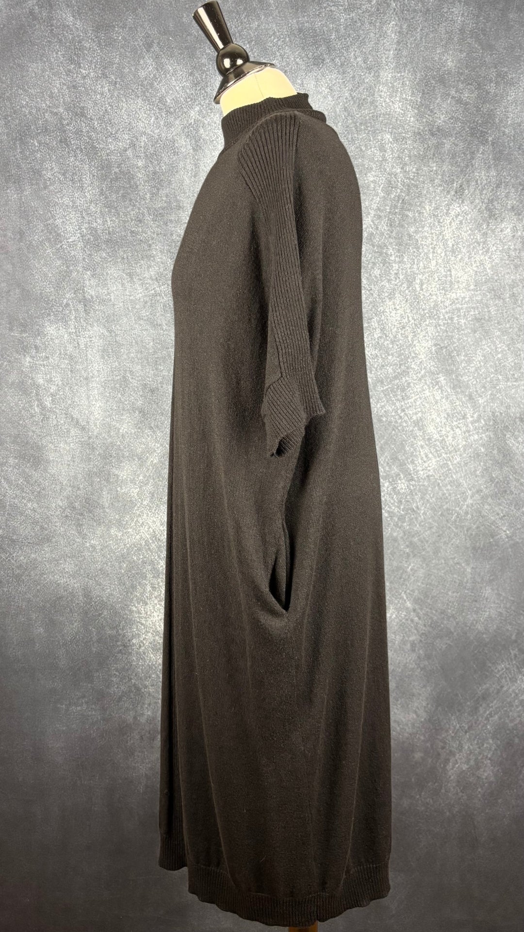 Robe mi-longue en tricot noir avec poches en mélange de laine mérinos Denis Gagnon + Edito par Simons, taille m/l. Vue de côté.