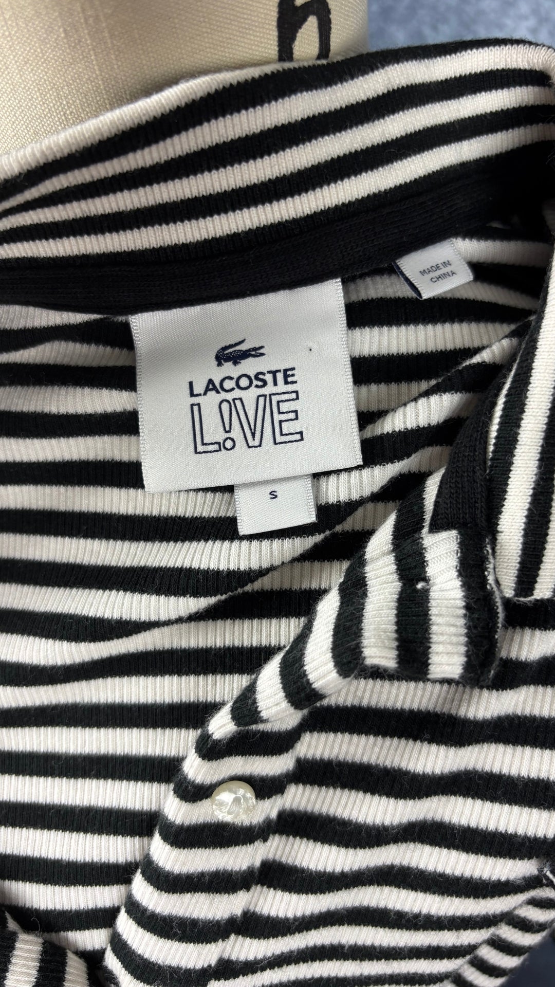 Robe polo à rayures noires et crème Lacoste Live, taille small. Vue de l'étiquette.