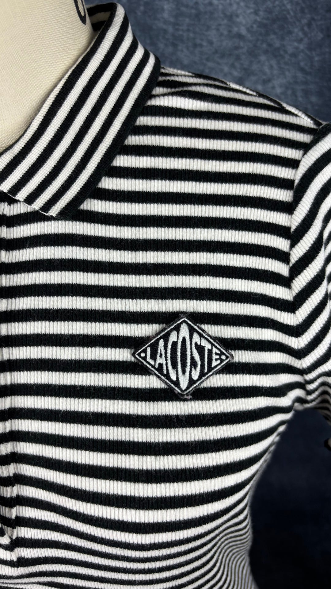 Robe polo à rayures noires et crème Lacoste Live, taille small. Vue de près du logo à la poitrine.