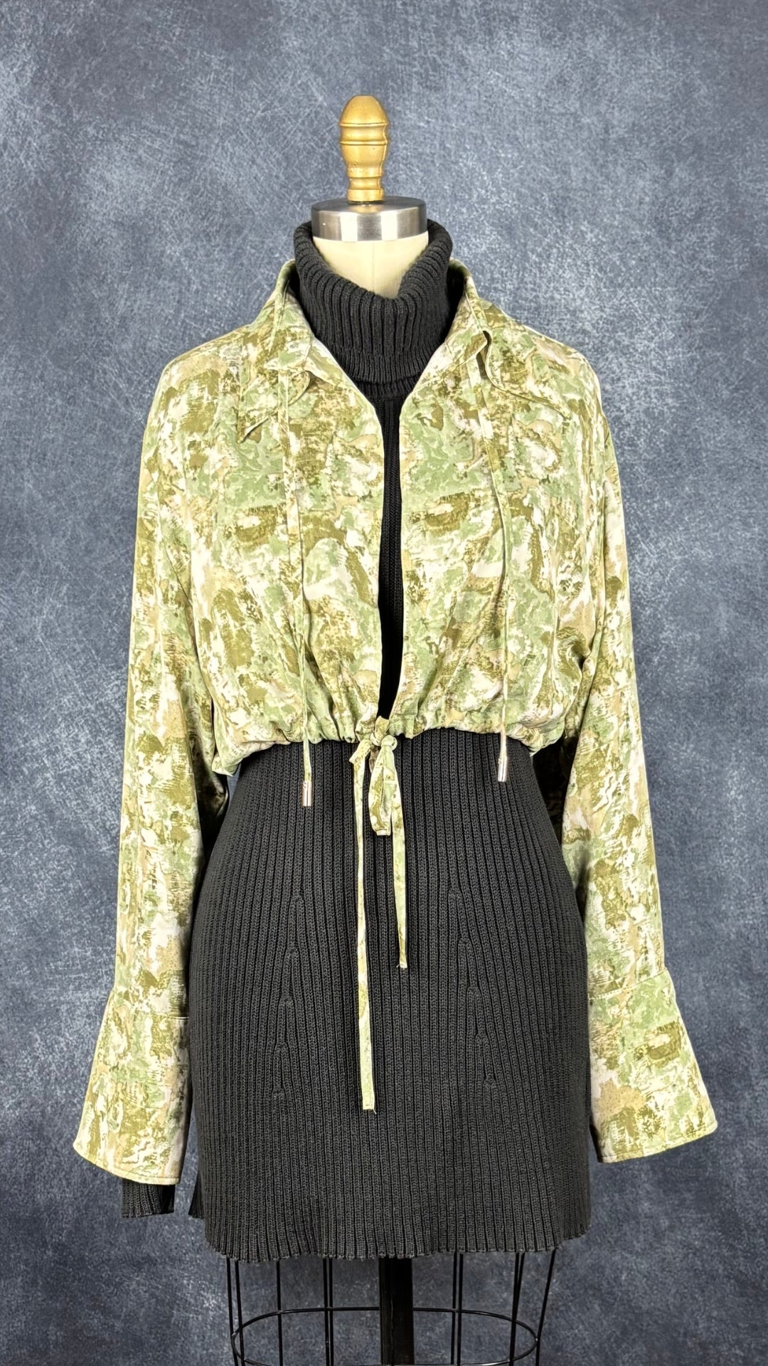 Robe tunique noire en tricot à col roulé Marc Cain, taille estimée à xs/s. Vue de l'agencement avec la petite veste courte dans les tons de beige et vert Joelle.