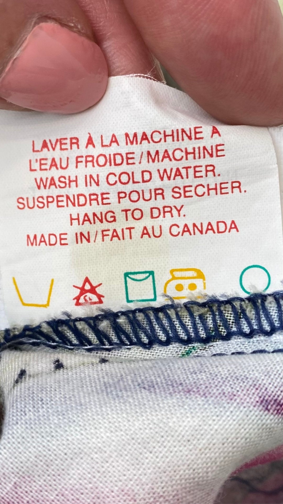 Robe vintage boutonnée à motifs de fleurs tropicales,  marque Relance, taille small, fabriquée au Canada. Vue de l'étiquette d'entretien.