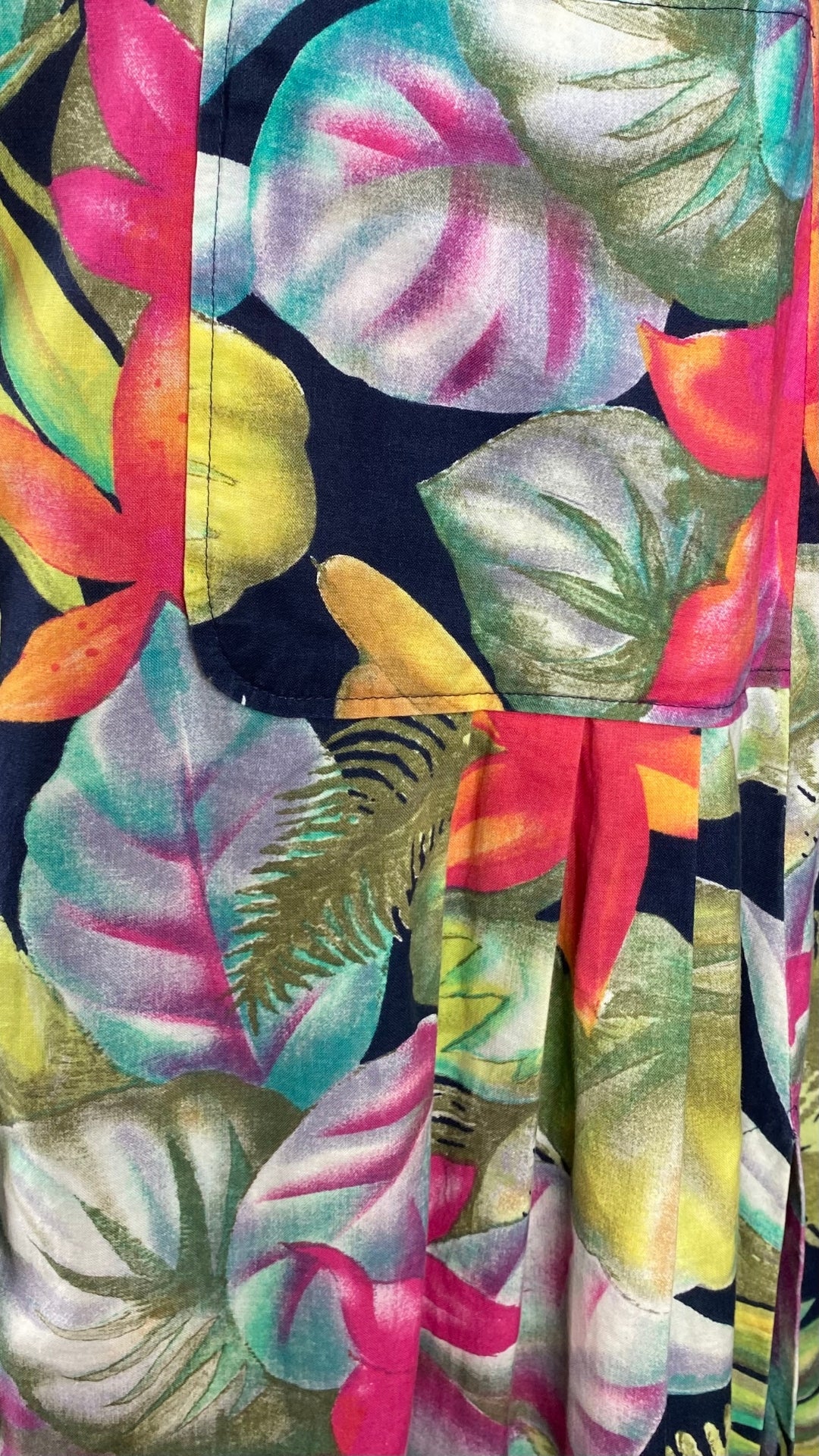 Robe vintage boutonnée à motifs de fleurs tropicales,  marque Relance, taille small, fabriquée au Canada. Vue de la poche et du plissé.