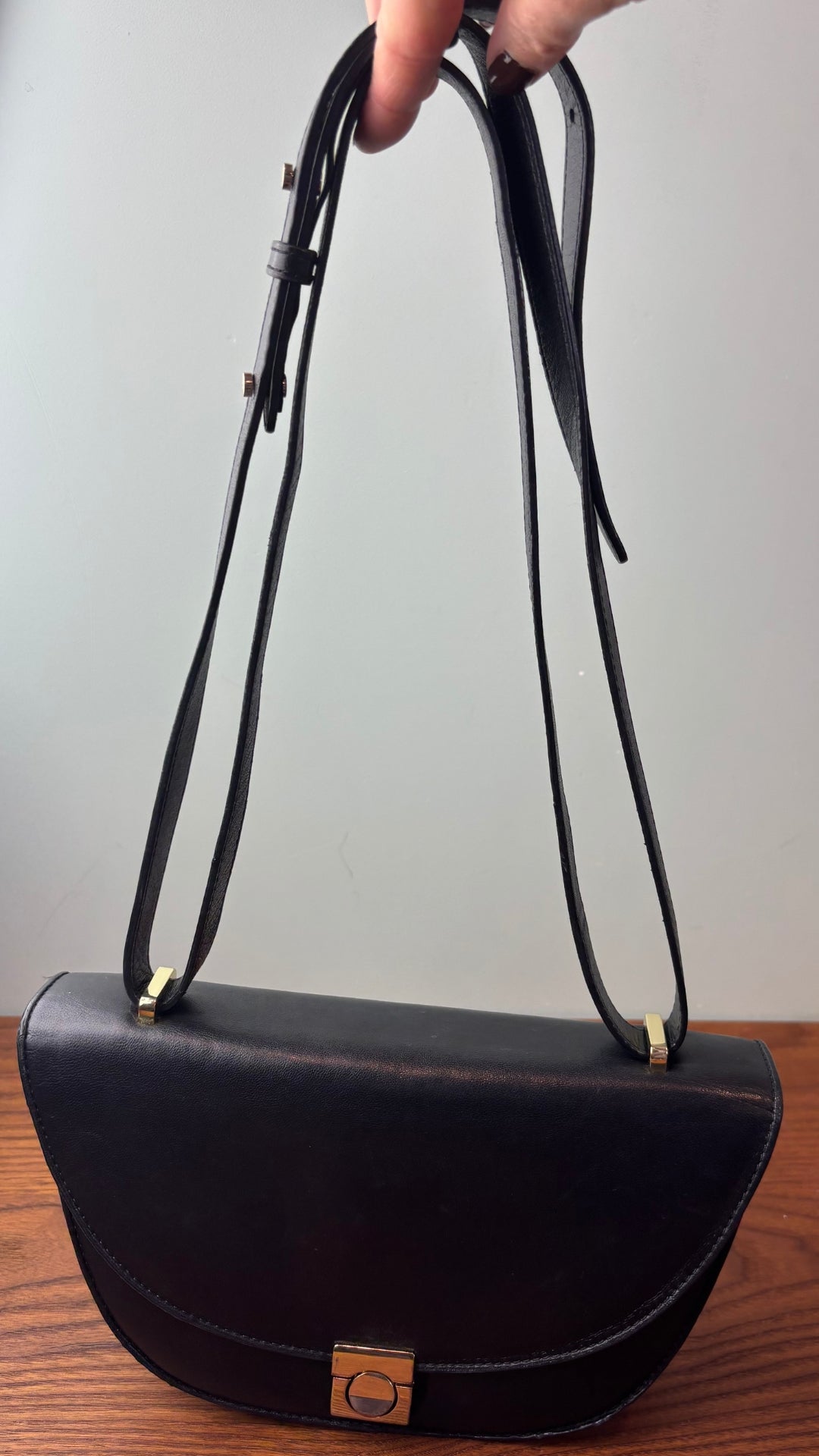 Sac en cuir lisse en demi-lune avec courroie type bandoulière, Flattered. Vue de la courroie lorsque doublée pour la raccourcir.