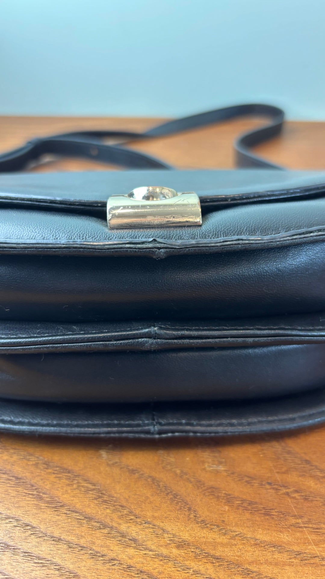 Sac en cuir lisse en demi-lune avec courroie type bandoulière, Flattered. Vue de près du dessous du sac.