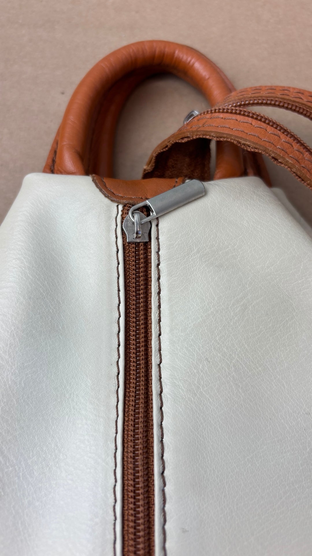 Sac à dos en cuir souple beige crème et brun tan Vera Pelle, fabriqué en Italie. Vue de la fermeture à glissière arrière.