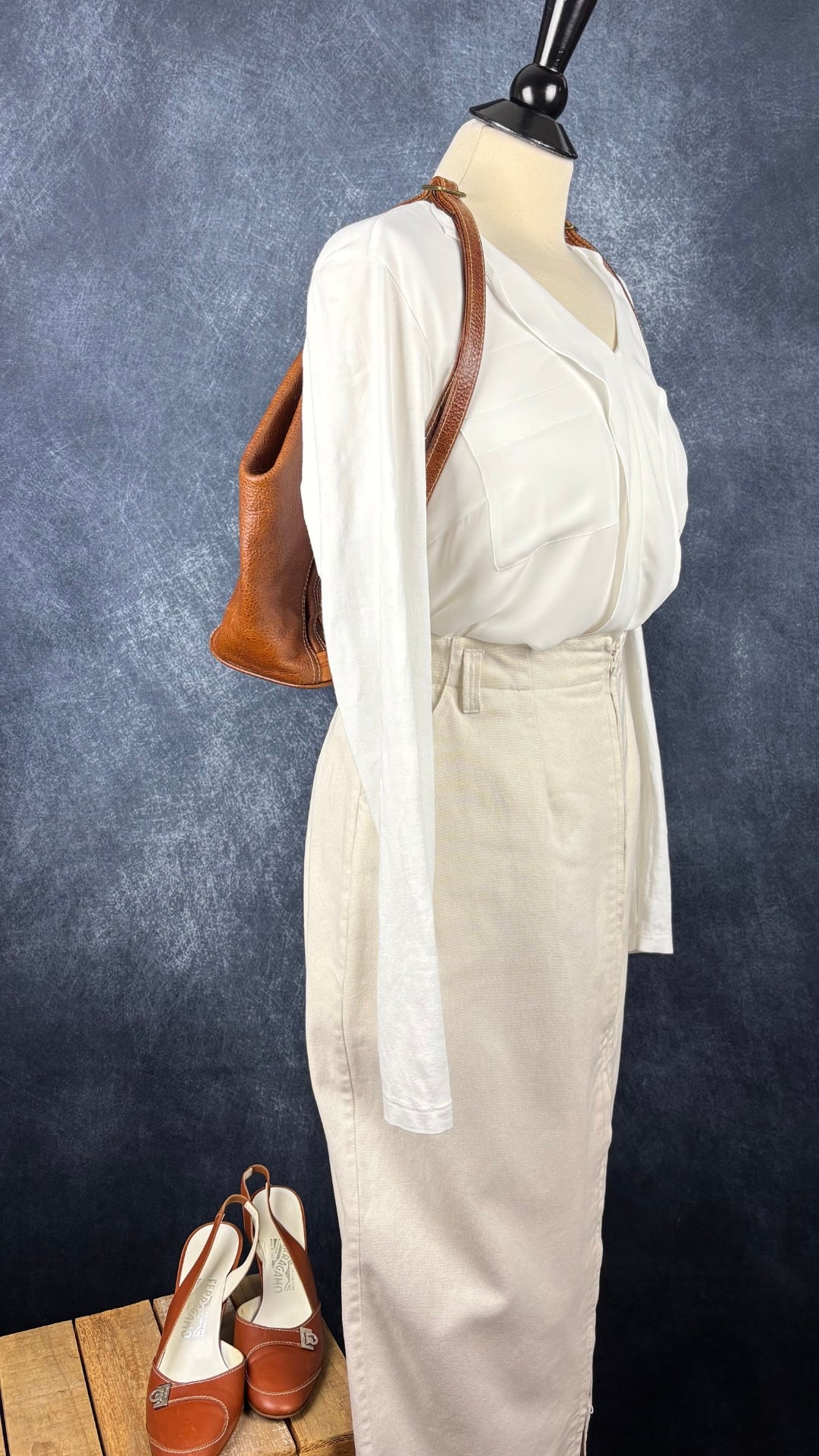 Sac à dos en cuir texturé brun et tan Matteo Mio. Vue de l'agencement avec la jupe crème Harly Jae, la blouse Olsen et les chaussures Salvatore Ferragamo.