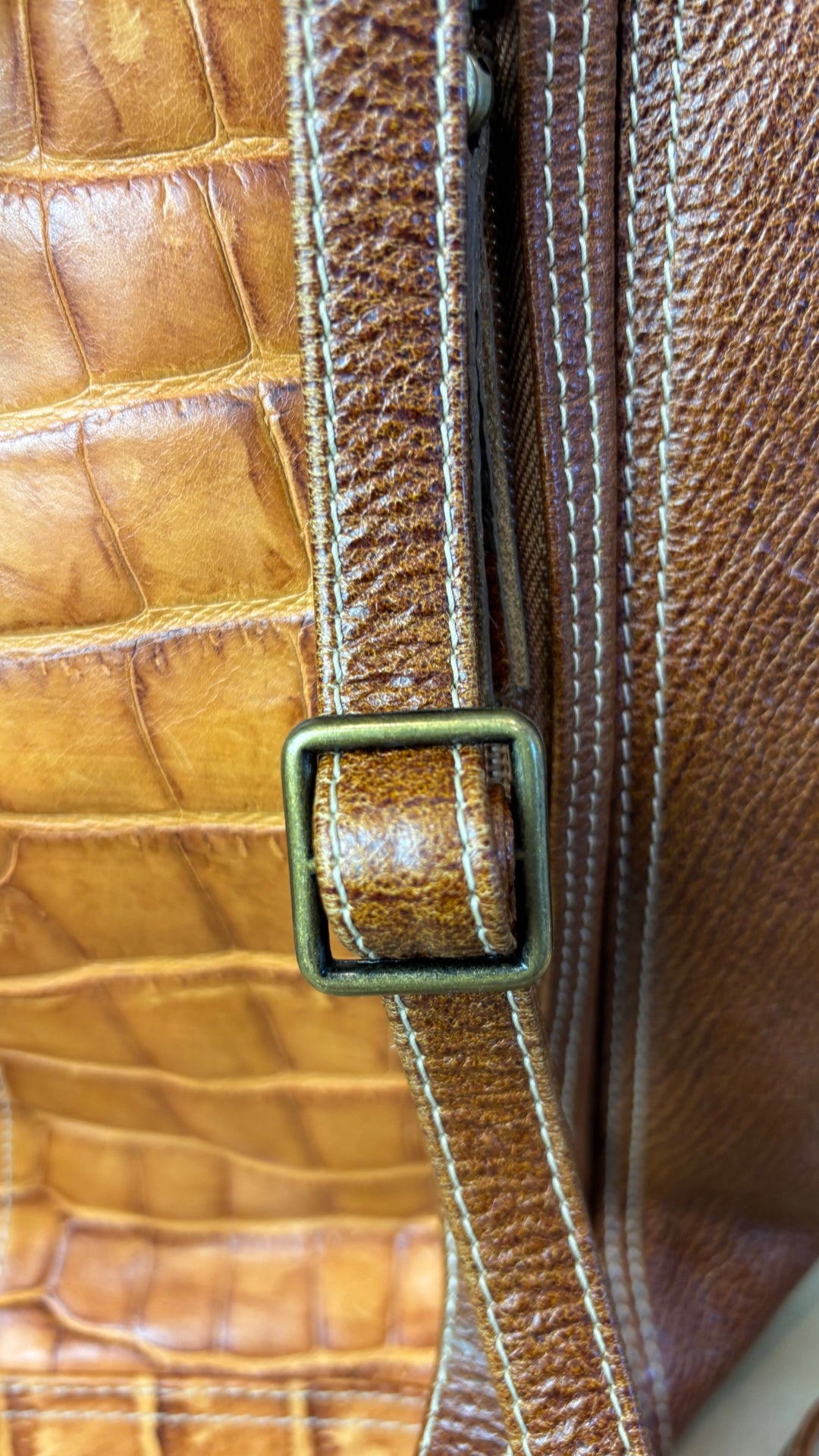 Sac à dos en cuir texturé brun et tan Matteo Mio. Vue de près des bretelles et ajustement.