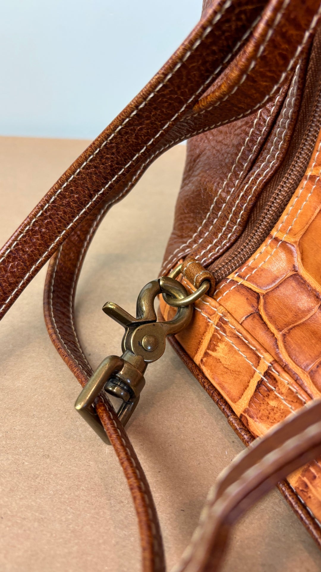 Sac à dos en cuir texturé brun et tan Matteo Mio. Vue de la quincaillerie en laiton vieilli du sac.