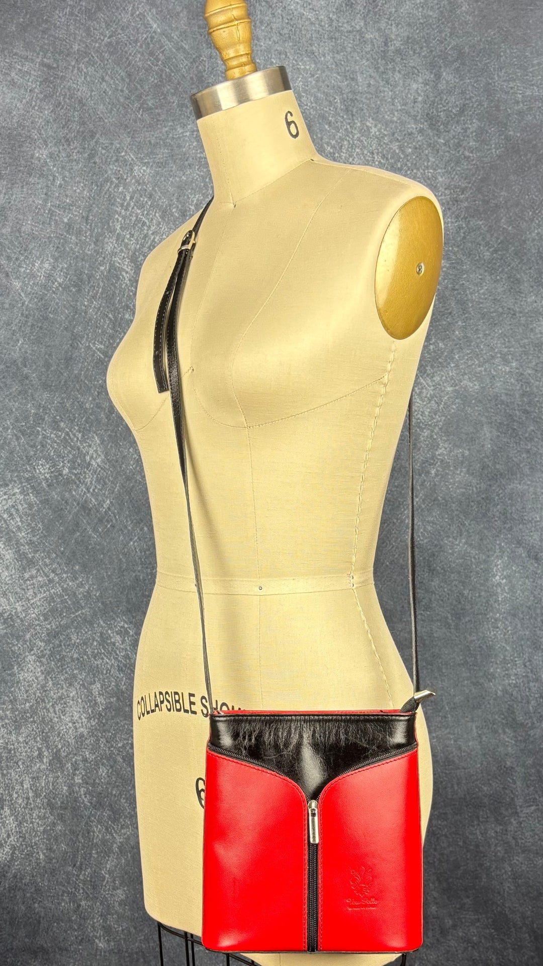 Sac à main en cuir noir et rouge à bandoulière Vera Pelle avec base ovale Vera Pelle. Vue de face, sur le mannequin.