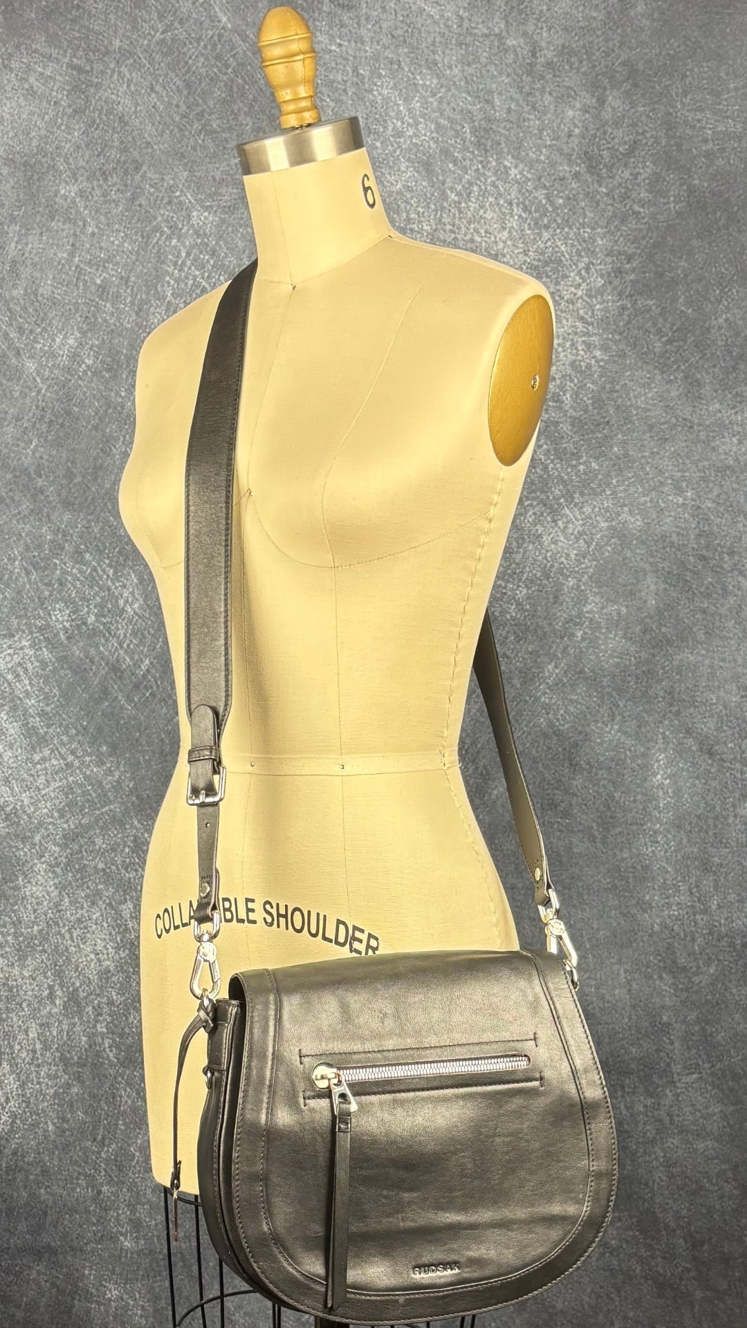 Sac à main en cuir noir Rudsak de taille moyenne avec coins de la base arrondis. Vue de face, sur le mannequin.