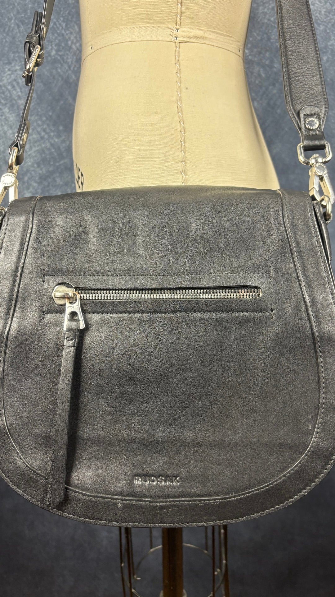 Sac à main en cuir noir Rudsak de taille moyenne avec coins de la base arrondis. Vue de près du sac, de face.