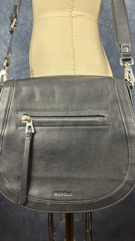 Sac à main en cuir noir Rudsak de taille moyenne avec coins de la base arrondis. Vue de près du sac, de face.