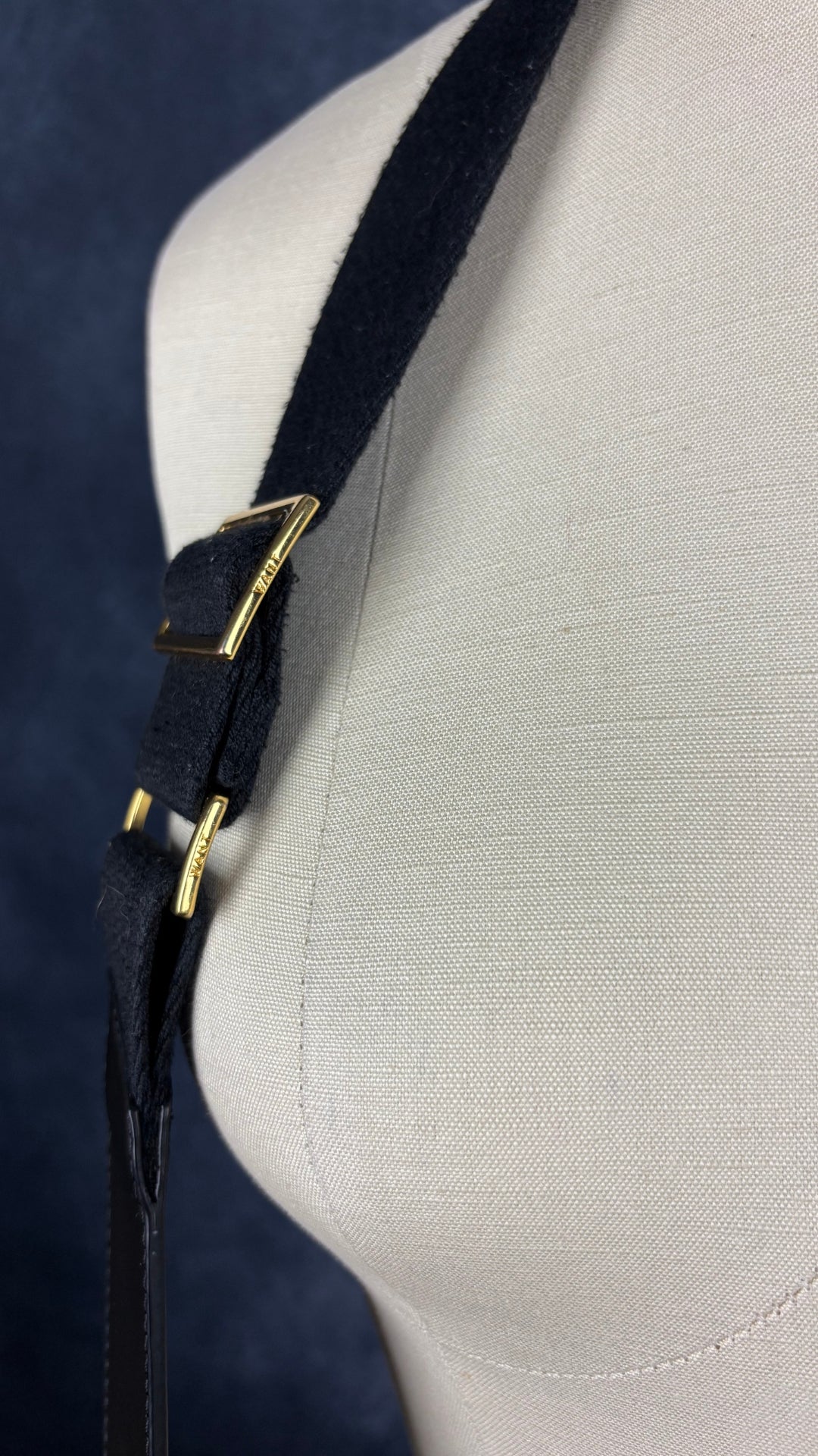 Sac sceau noir à poignée et bandoulière en cuir Want Les Essentiels. Vue de près de la partie qui permet l'ajustement de la courroie amovible.