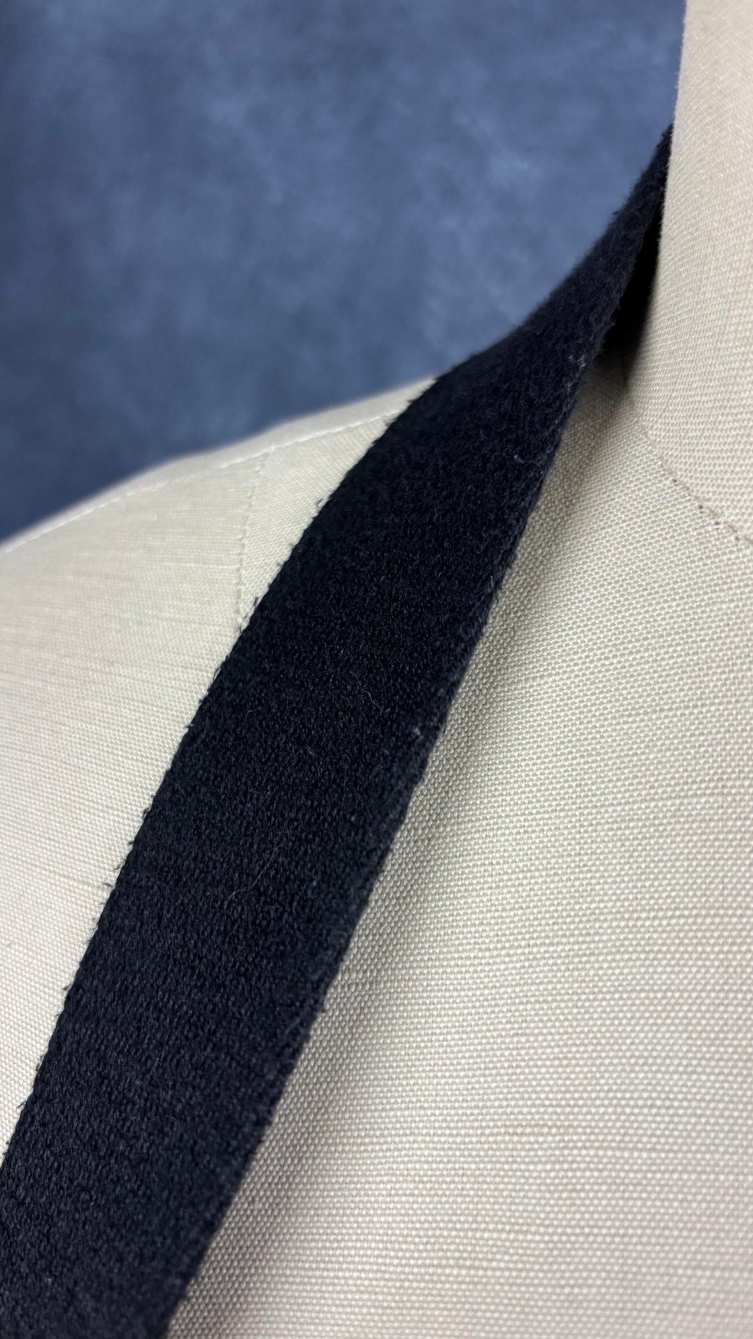 Sac sceau noir à poignée et bandoulière en cuir Want Les Essentiels. Vue de près de la courroie amovible en tissu, présence de petites bouloches.