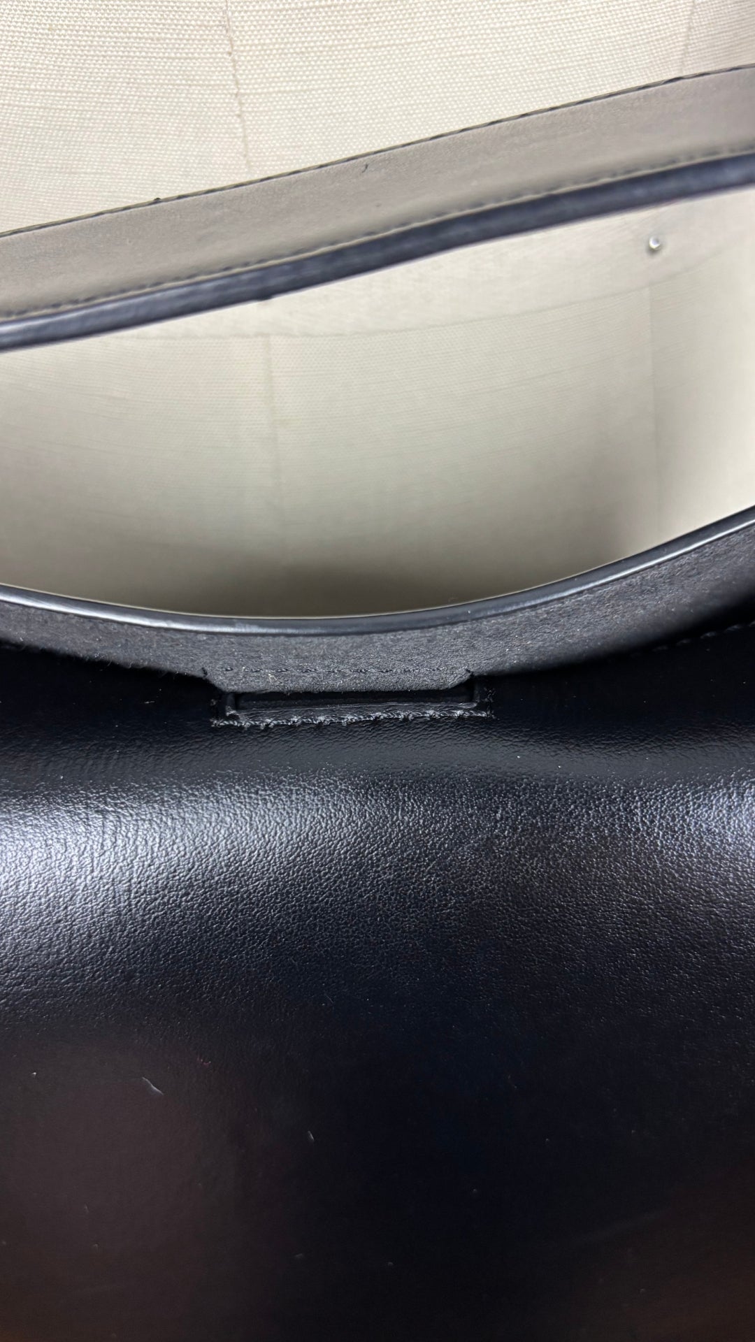 Sac sceau noir à poignée et bandoulière en cuir Want Les Essentiels. Vue de près du fermoir aimanté.