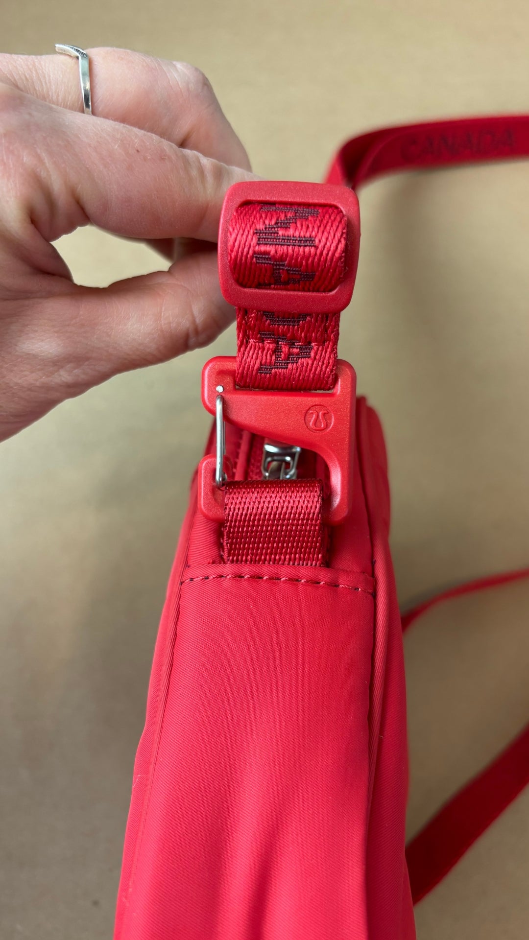 Sac Team Canada 22 Future Legacy cramoisie Lululemon. Vue de la courroie et de l'ajustement.