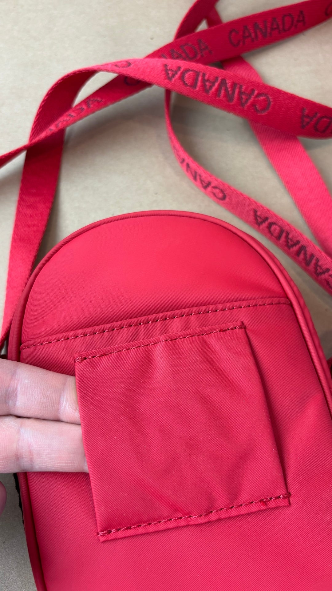 Sac Team Canada 22 Future Legacy cramoisie Lululemon. Vue du passant pour porter le sac à la taille.