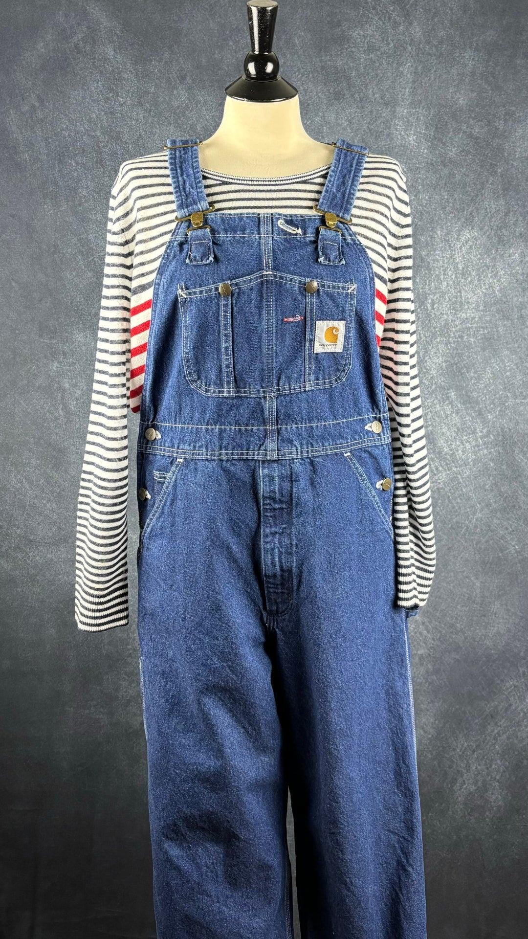 Salopette en jeans foncé Carhartt, taille 32. Vue de l'agencement avec le chandail à rayures Brax.