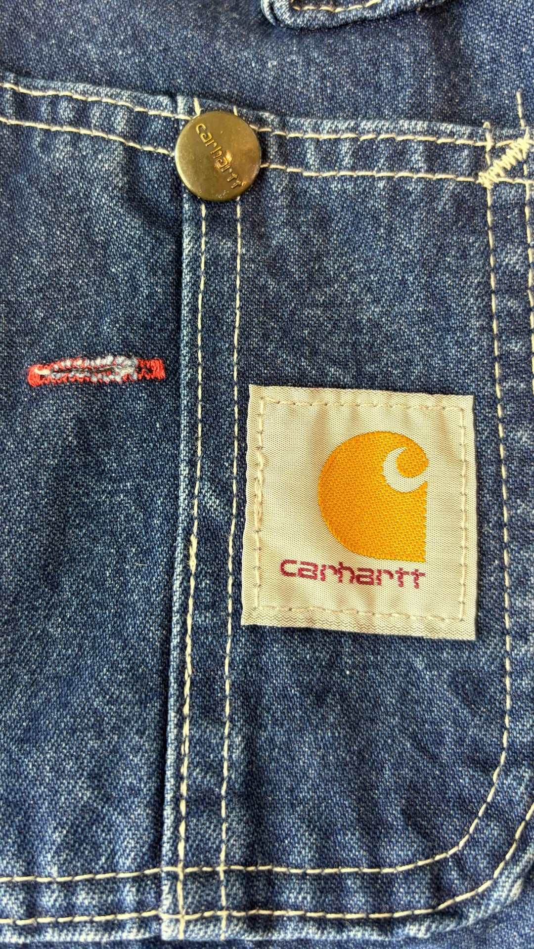 Salopette en jeans foncé Carhartt, taille 32. Vue de la poche avant de près.