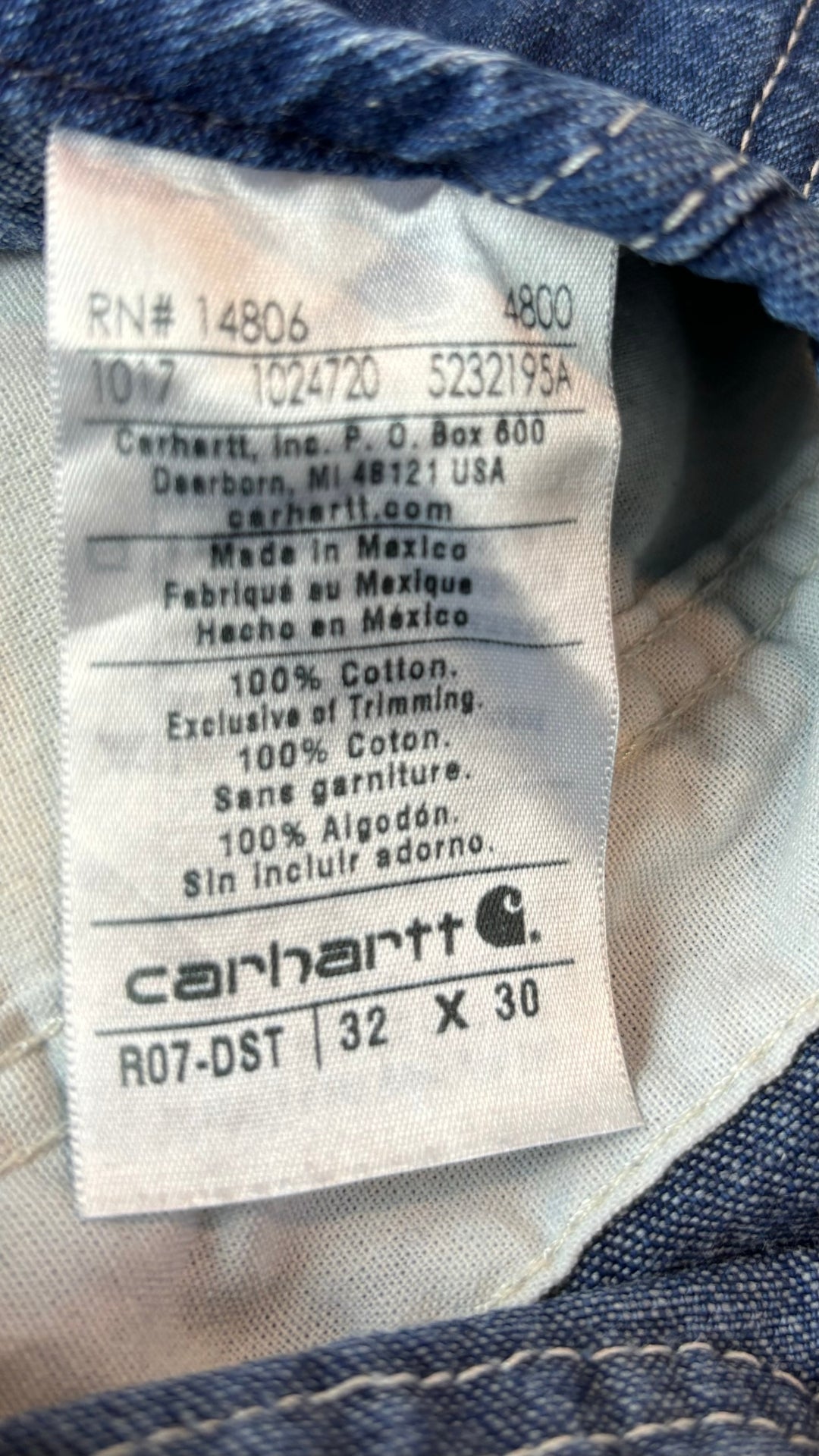 Salopette en jeans foncé Carhartt, taille 32. Vue de l'étiquette.