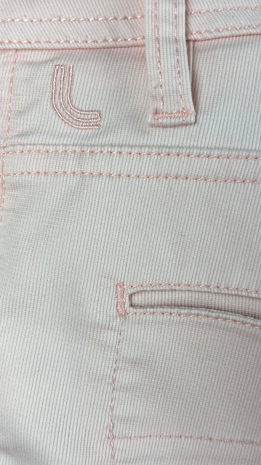Short rose doux Lolë, taille estimée à large. Vue de près du logo brodé au dos.