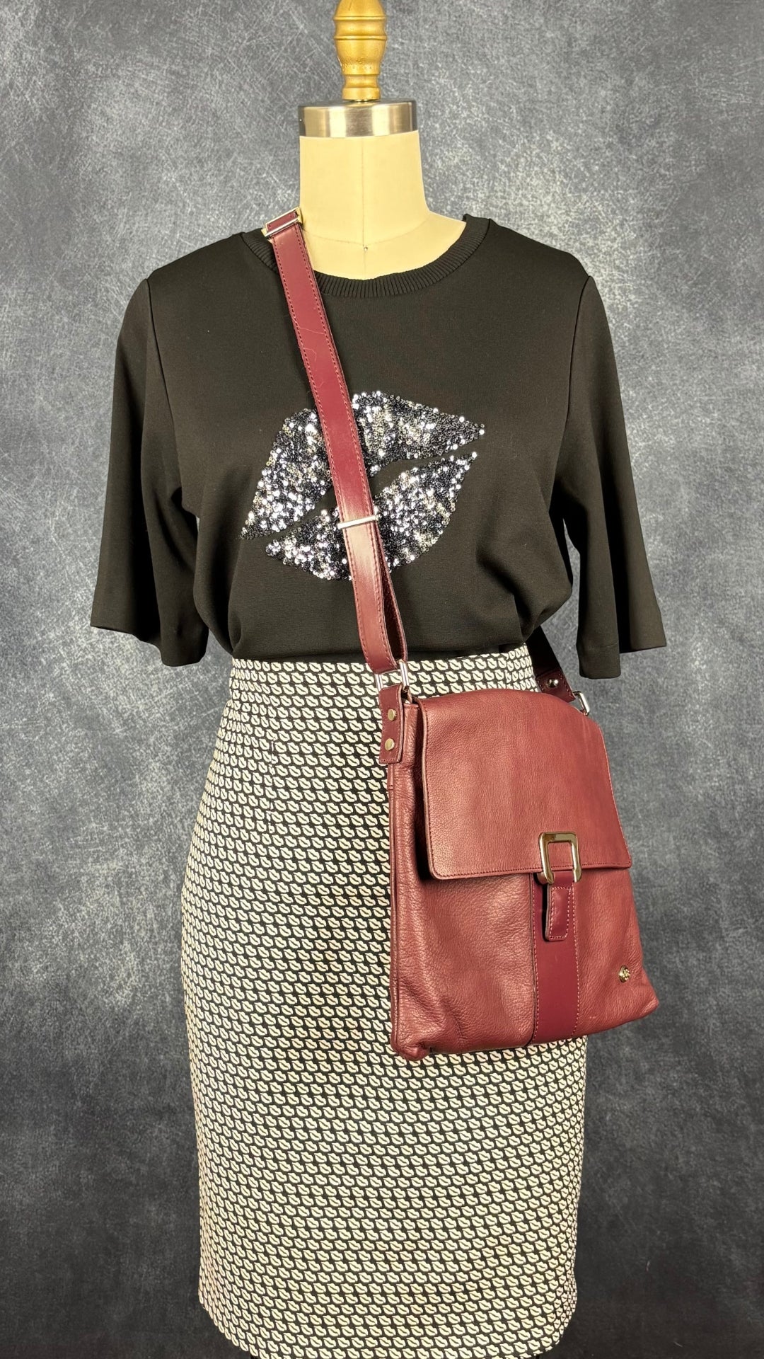 T-shirt noir avec lèvres en sequins au centre, InWear, taille small. Vue de l'agencement avec la jupe à motifs de lèvres et le sac à main bordeaux The Trend.