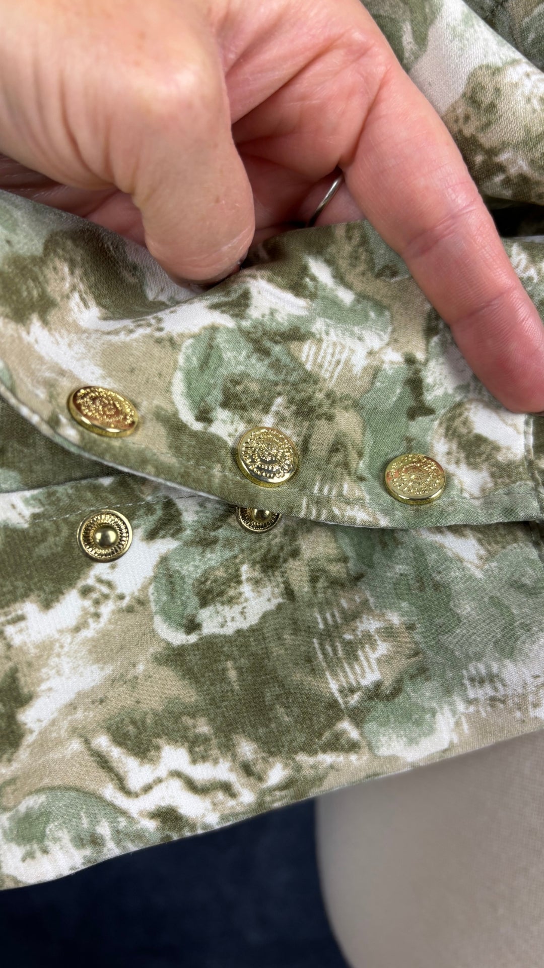 Veste courte à col chemisier à motifs abstraits Joelle, taille small. Vue de près des boutons-pression ouverts.