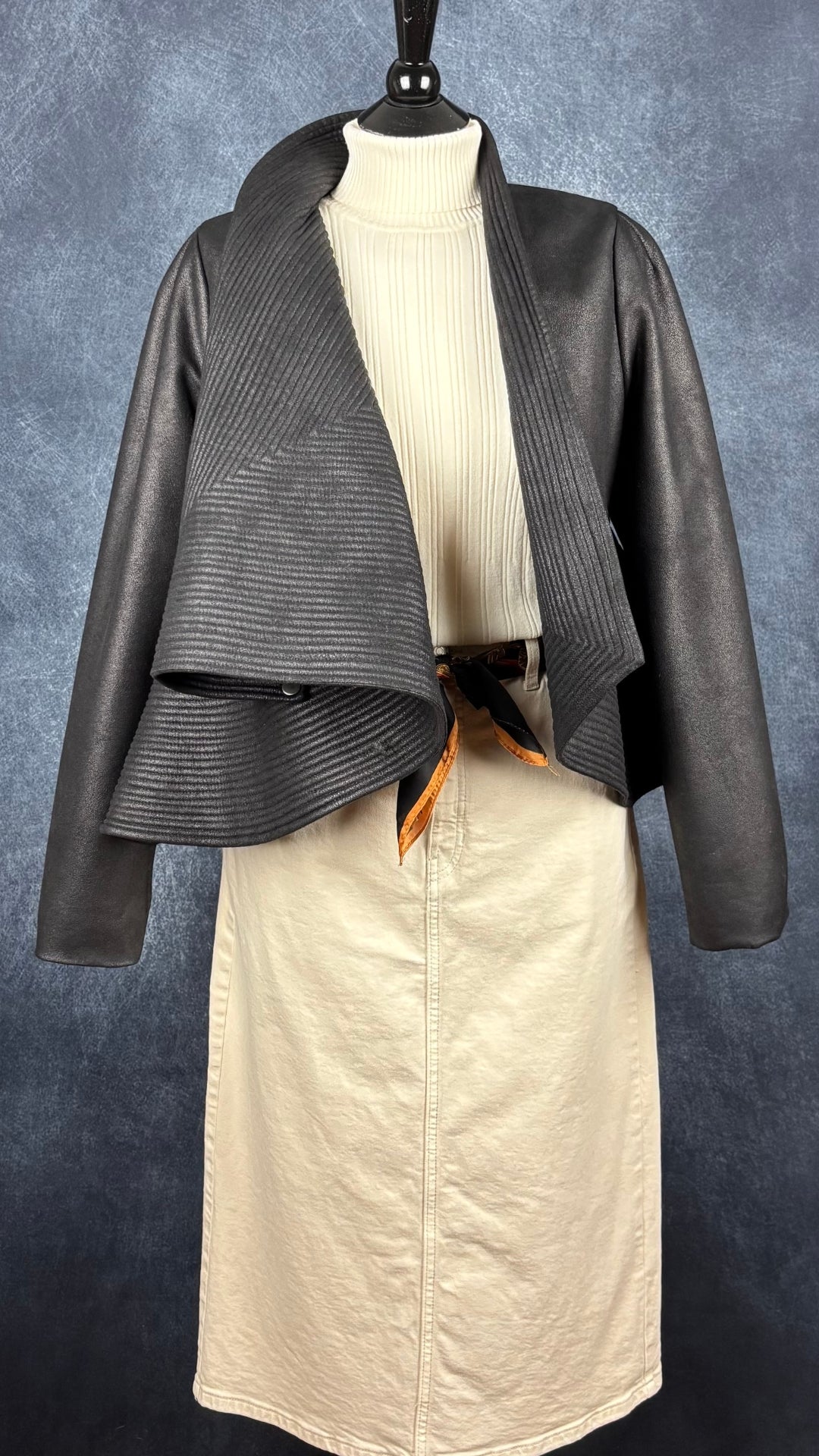 Veste design asymétrique à grand col charcoal Tom Adrian, taille estimée à small. Vue de l'agencement avec le col roulé crème, la jupe en denim écru et le foulard coloré.