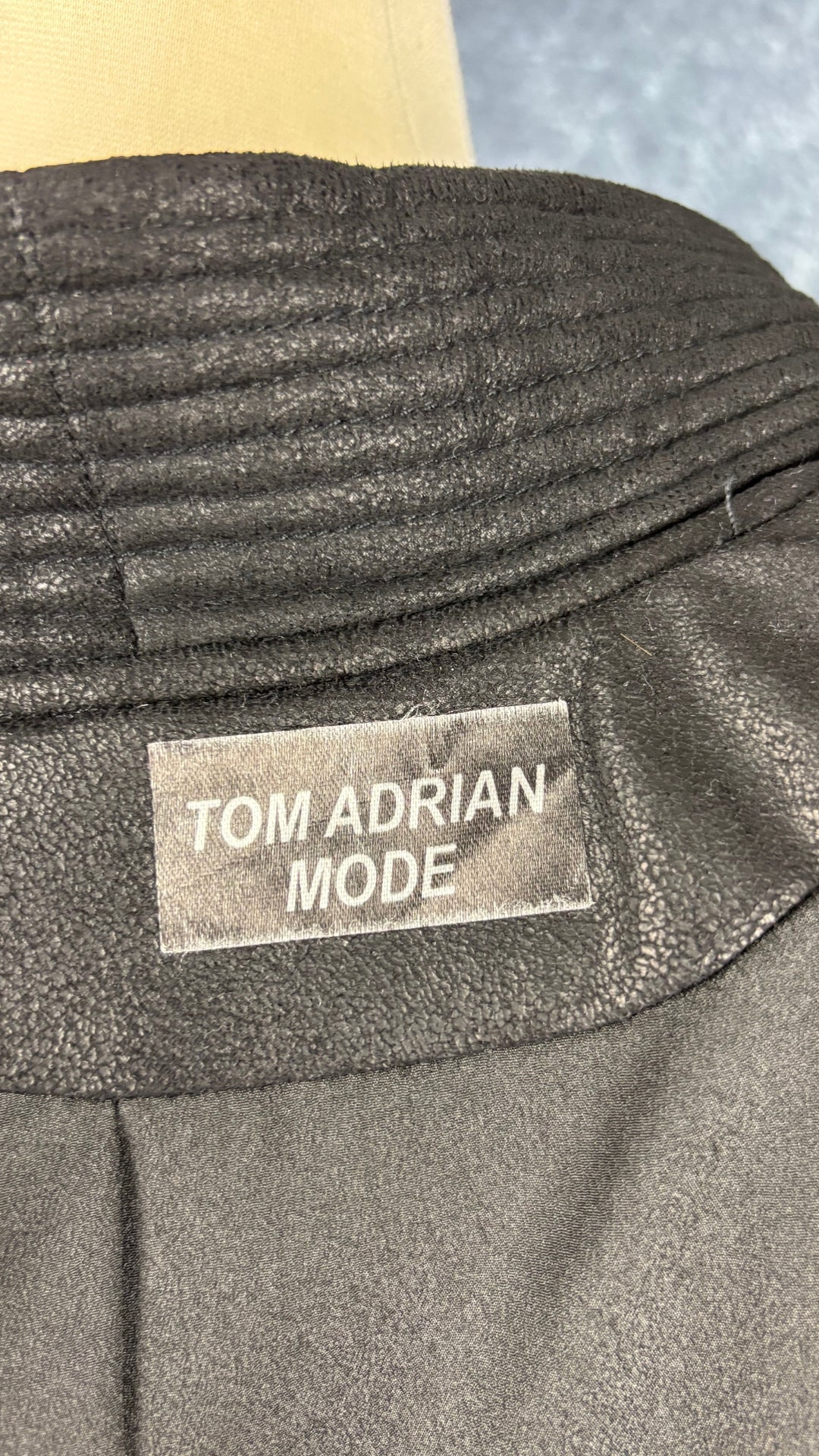 Veste design asymétrique à grand col charcoal Tom Adrian, taille estimée à small. Vue de l'étiquette.