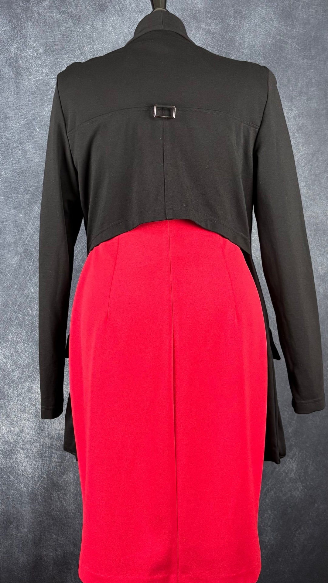 Veste déstructurée asymétrique noire Sarah Pacini, taille 3 (large). Vue de dos avec la robe rouge à manches gigots Calvin Klein.