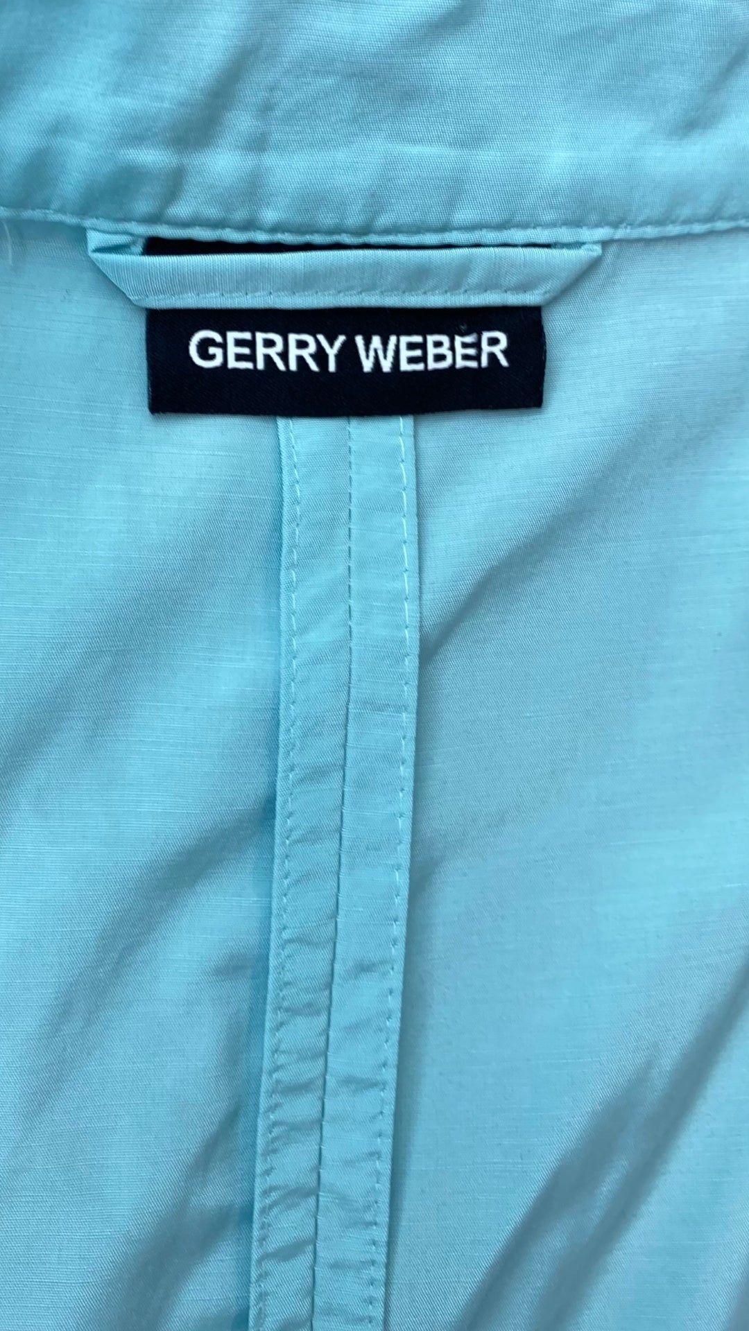 Veste légère aqua avec bouton en forme de fleur Gerry Weber, taille estimée medium. Vue de l'étiquette de marque.