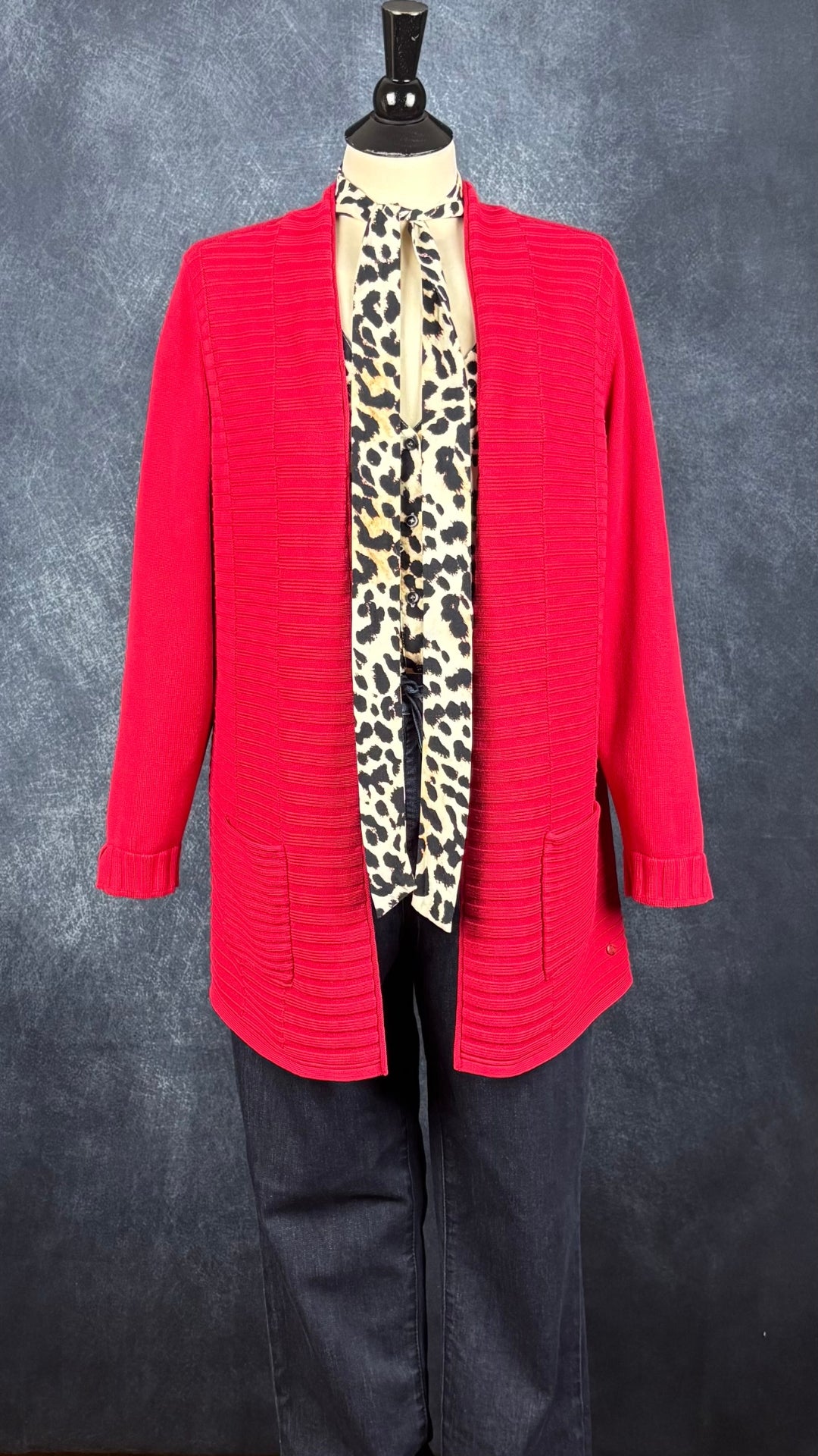 Veste mi-longue en tricot rouge Olsen, taille large (14). Vue de l'agencement avec le jeans foncé Tristan et la blouse à motifs animaliers Marc Aurel.