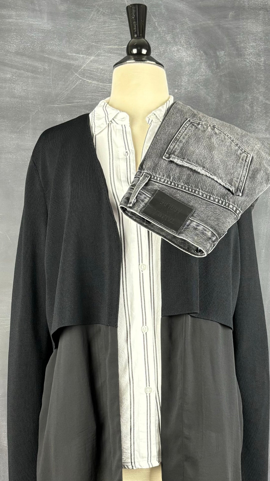 Veste noire longue bi-matière Cos, taille xs. Vue de l'agencement avec le chemisier en fine flanelle à rayures et le jeans Agolde x Talula.