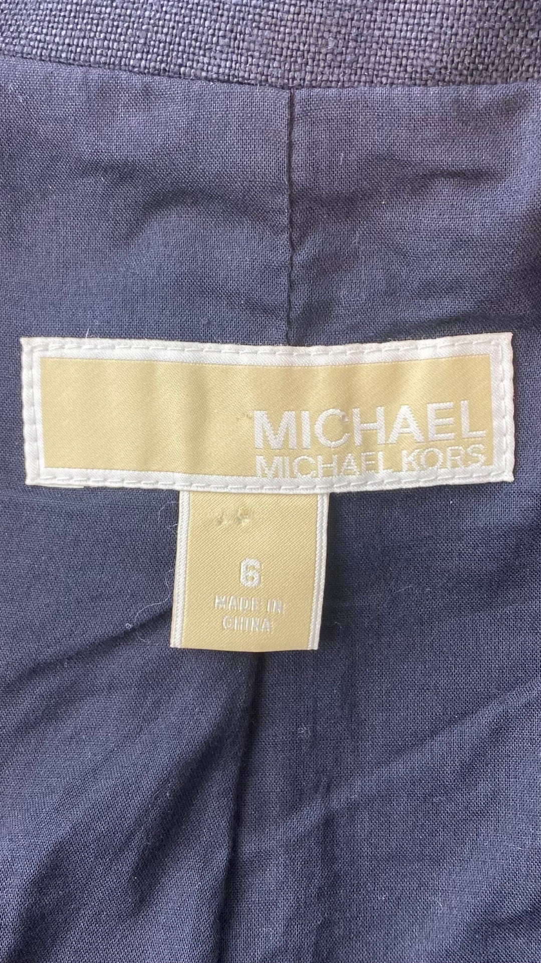 Veston estival parfait, ce blazer marine en lin Michael Kors est une base pour les températures chaudes. Vue de l'étiquette de marque et taille.