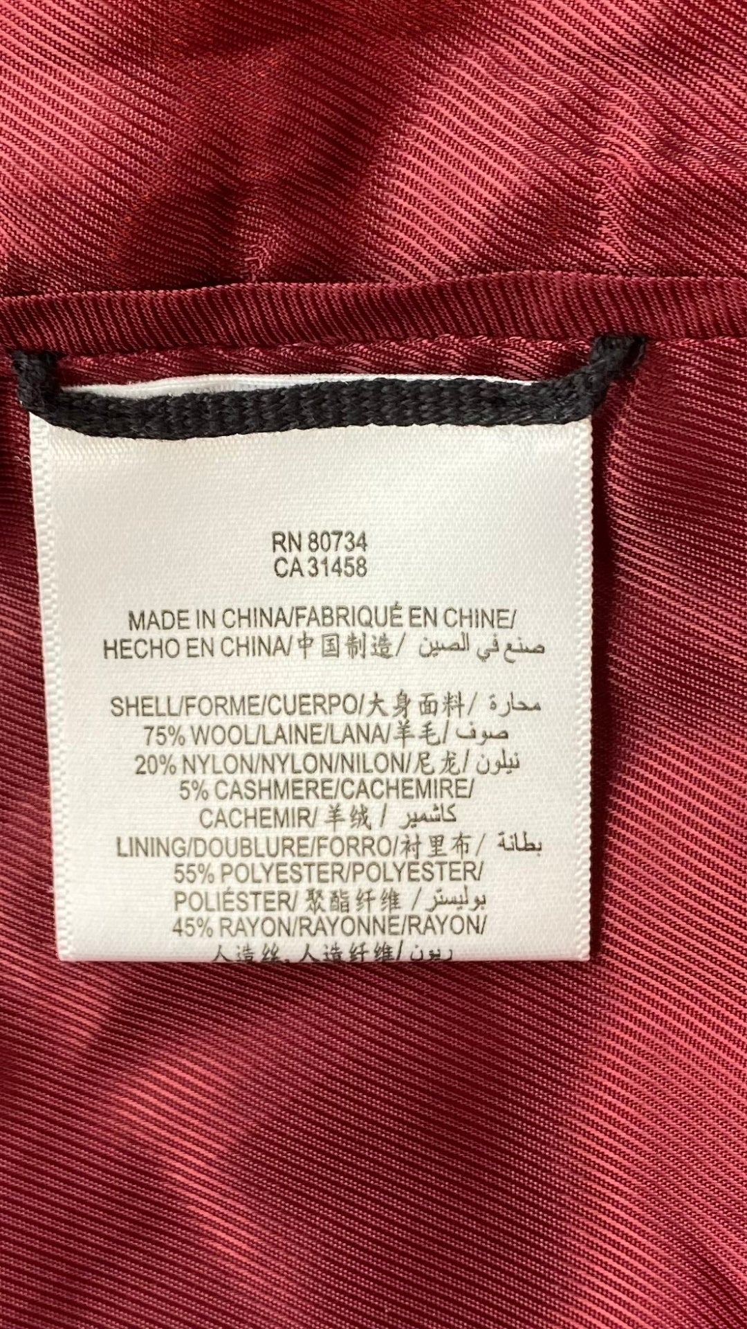 Manteau assez long en lainage rouge, manches ballons, BCBGMAXAZRIA, vue de l'étiquette de composition.