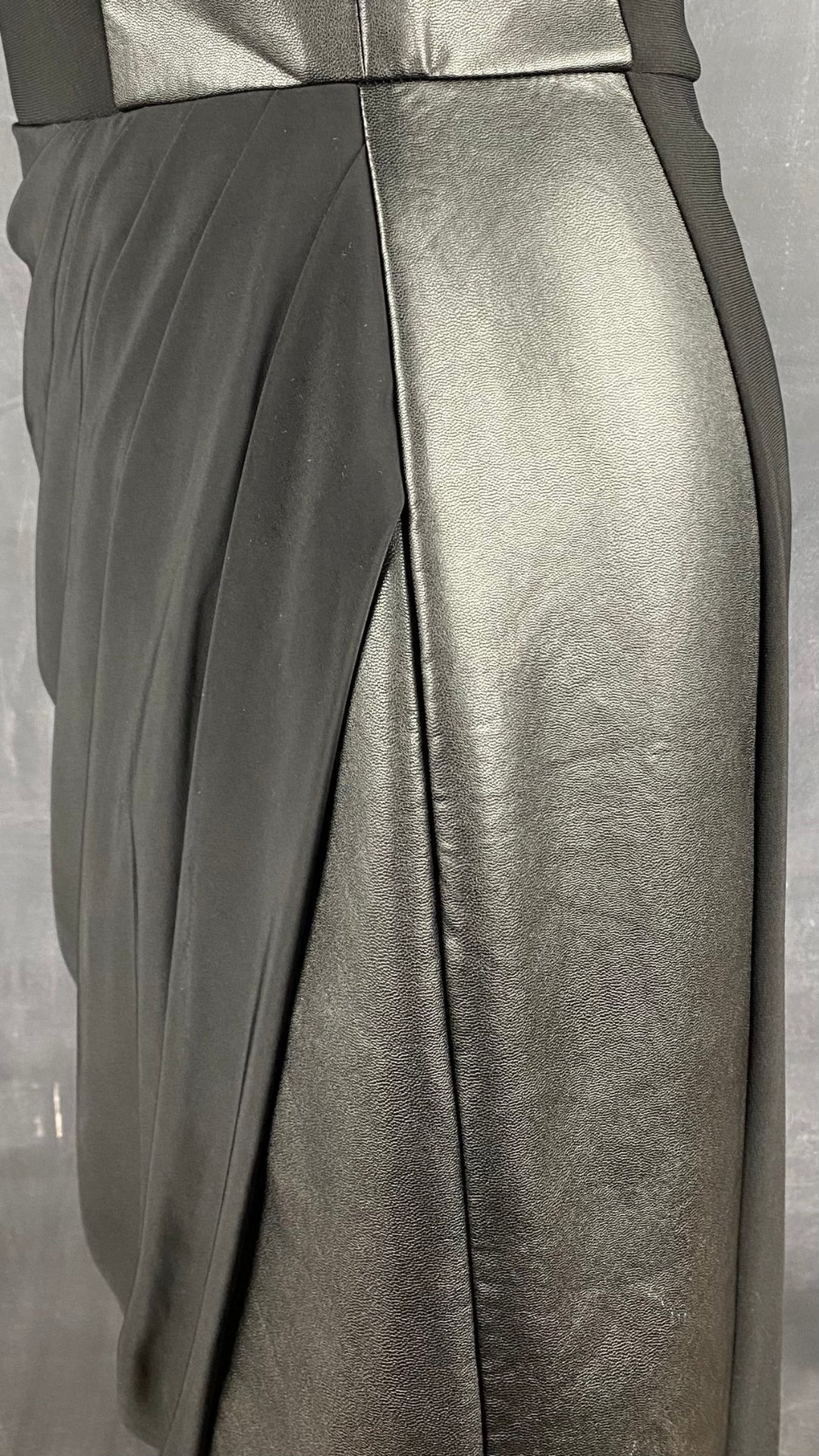 Robe Frank Lyman drapée noire et faux cuir. Vue de près des détails de la jupe.