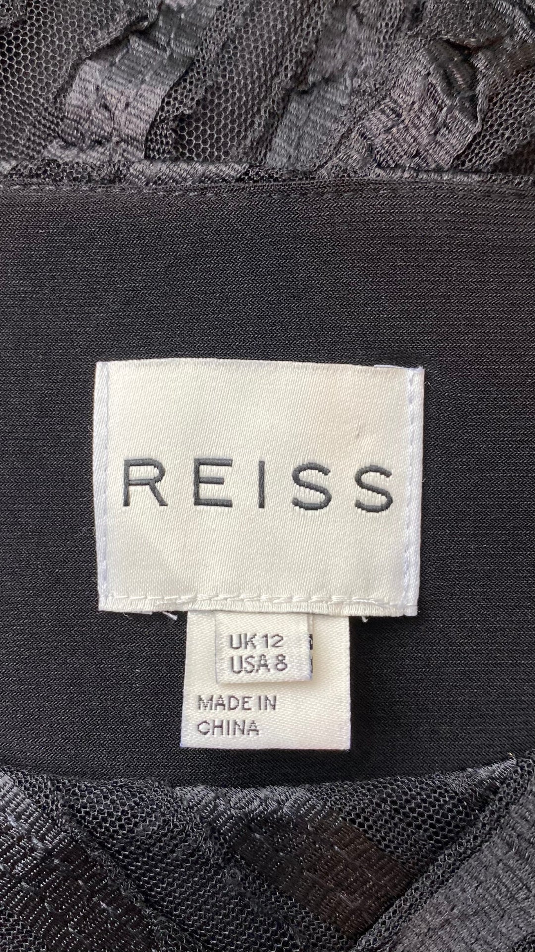 Robe sublime noire en transparence et effet de rayures créées par des juxtaposition de tissus. Vue de l'étiquette de marque et taille.